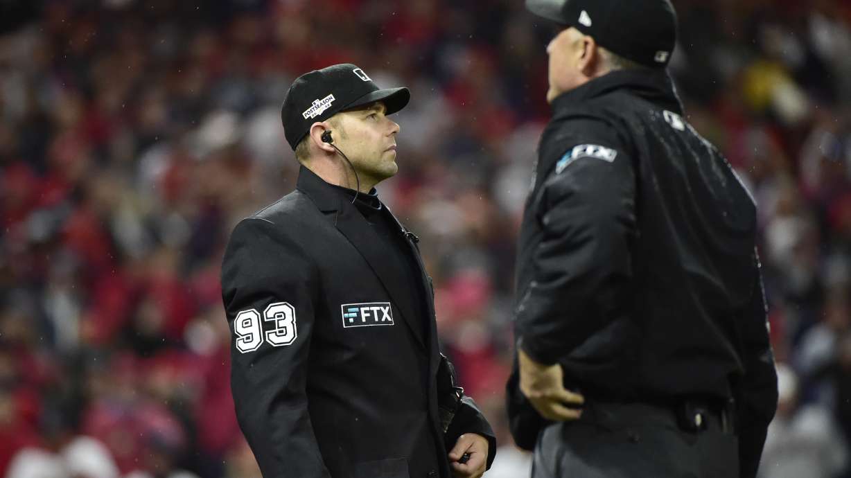 Umpires Will Little, left, and Dan Iassogna, right, review a play on whether or not Cleveland Guardians' Andres Gimenez was hit-by-pitch in the fourth inning of Game 4 of a baseball AL Division Series against the New York Yankees, Sunday, Oct. 16, 2022, in Cleveland.