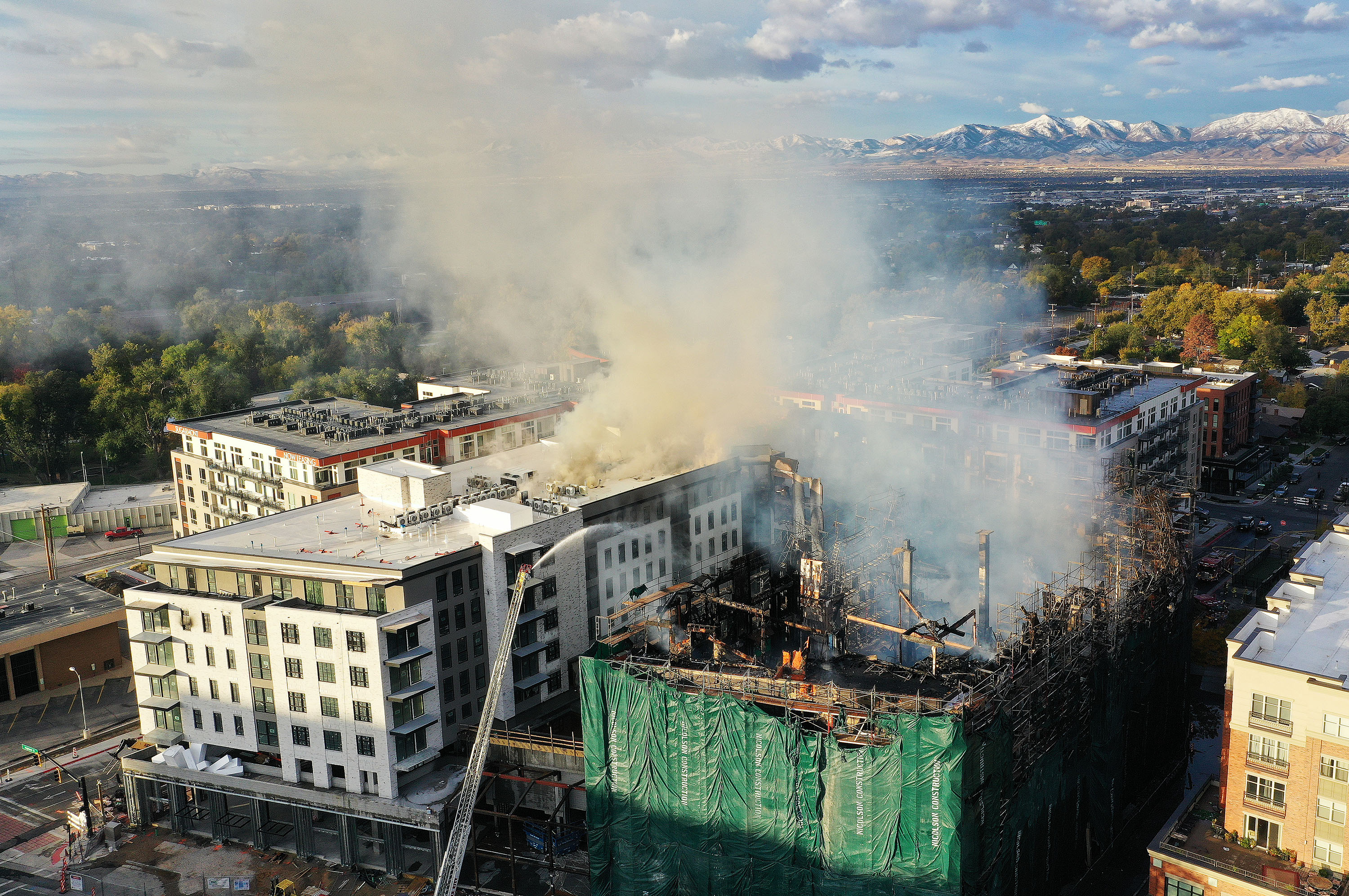 A firefighter pours water on a blaze at an apartment building under construction near 1040 E. 2220 South in Sugar House in Salt Lake City on Wednesday. The fire, which started Tuesday night, prompted the overnight evacuation of hundreds of nearby residents.