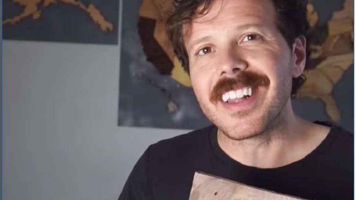 Justin Davies poses in front of a U.S. map he created using trees native to each state.