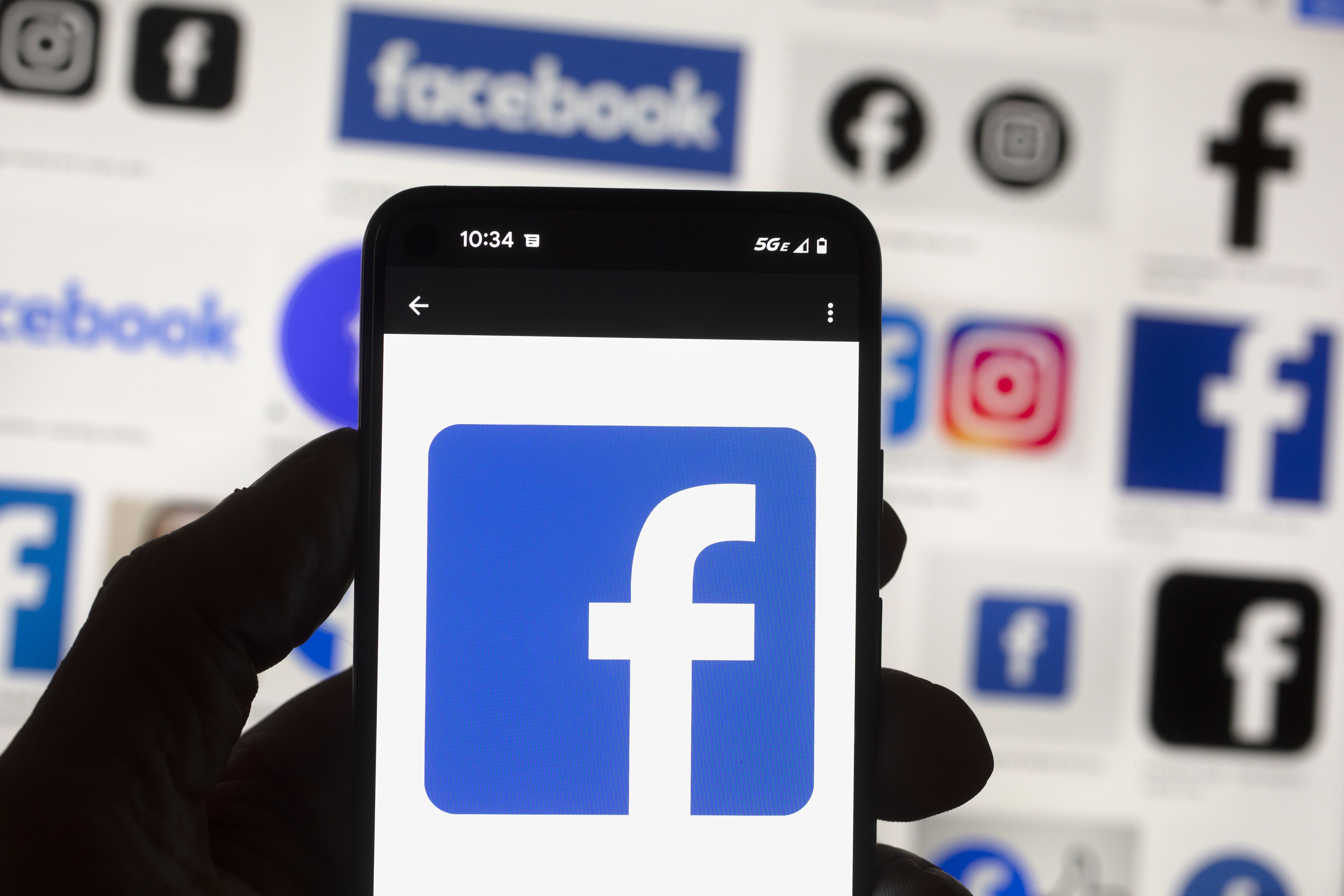 The Facebook logo is seen on a cell phone on Oct. 14 in Boston. A Washington state judge on Wednesday fined Facebook parent company Meta nearly $25 million for repeatedly and intentionally violating campaign finance disclosure law, in what is believed to be the largest campaign finance penalty in U.S. history. 