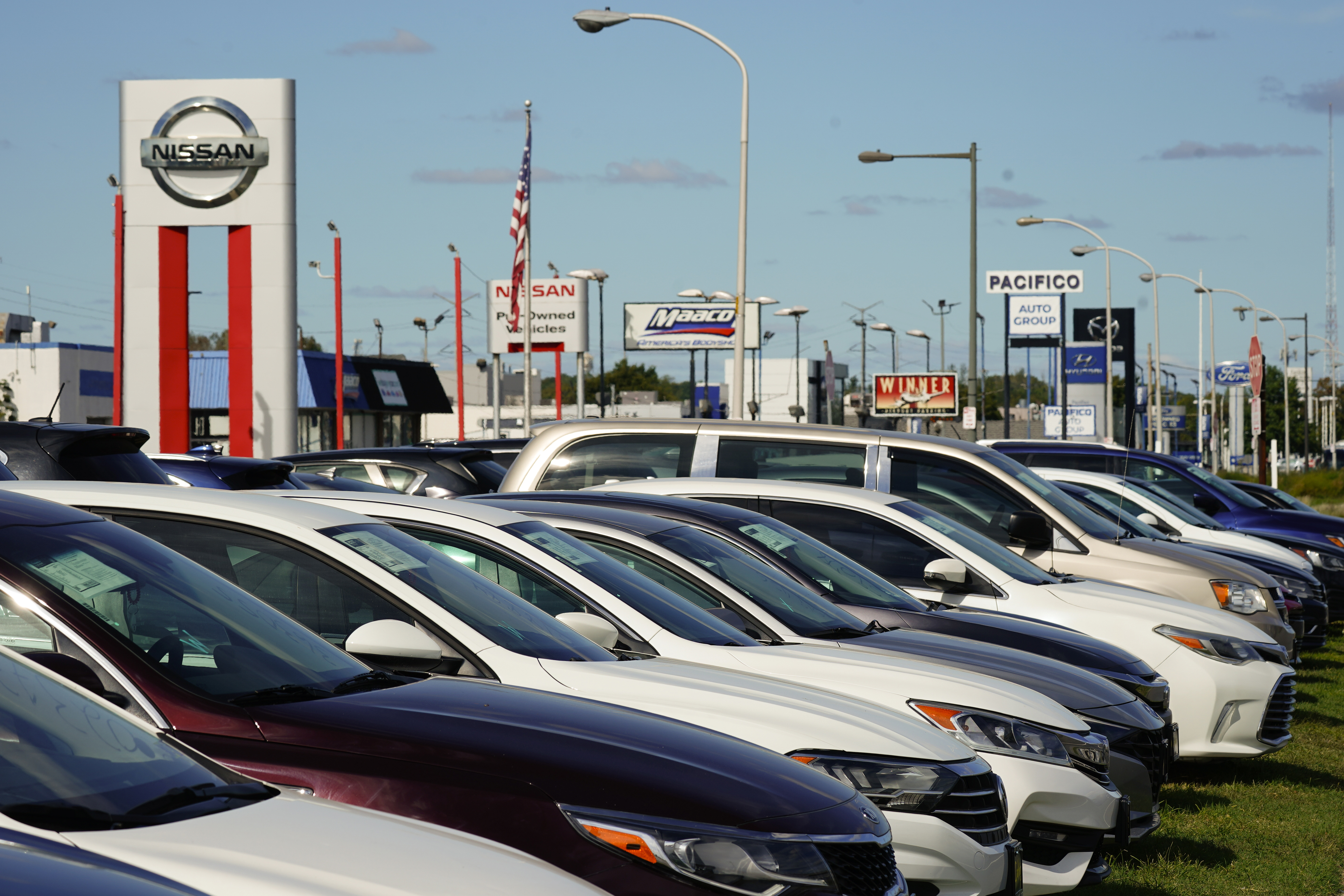 Cars for sale line the road at a used auto dealership in Philadelphia on Sept. 29. The prices of new and used vehicles in the United States have begun inching down from their eye-watering record highs as more vehicles have become gradually available at dealerships. 