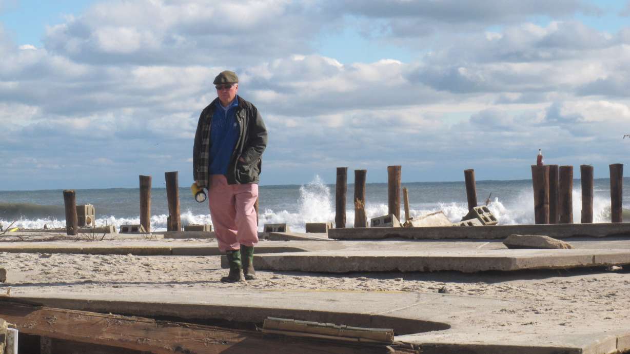 In this Oct. 31, 2012, photo, Peter Green surveys the wreckage of an oceanfront home in Bay Head, N.J., two days after Superstorm Sandy hit. Ten years later, government officials and residents say much has been done to prepare for future storms but caution that much more still remains to be done in an era of rising sea levels and a changing climate.