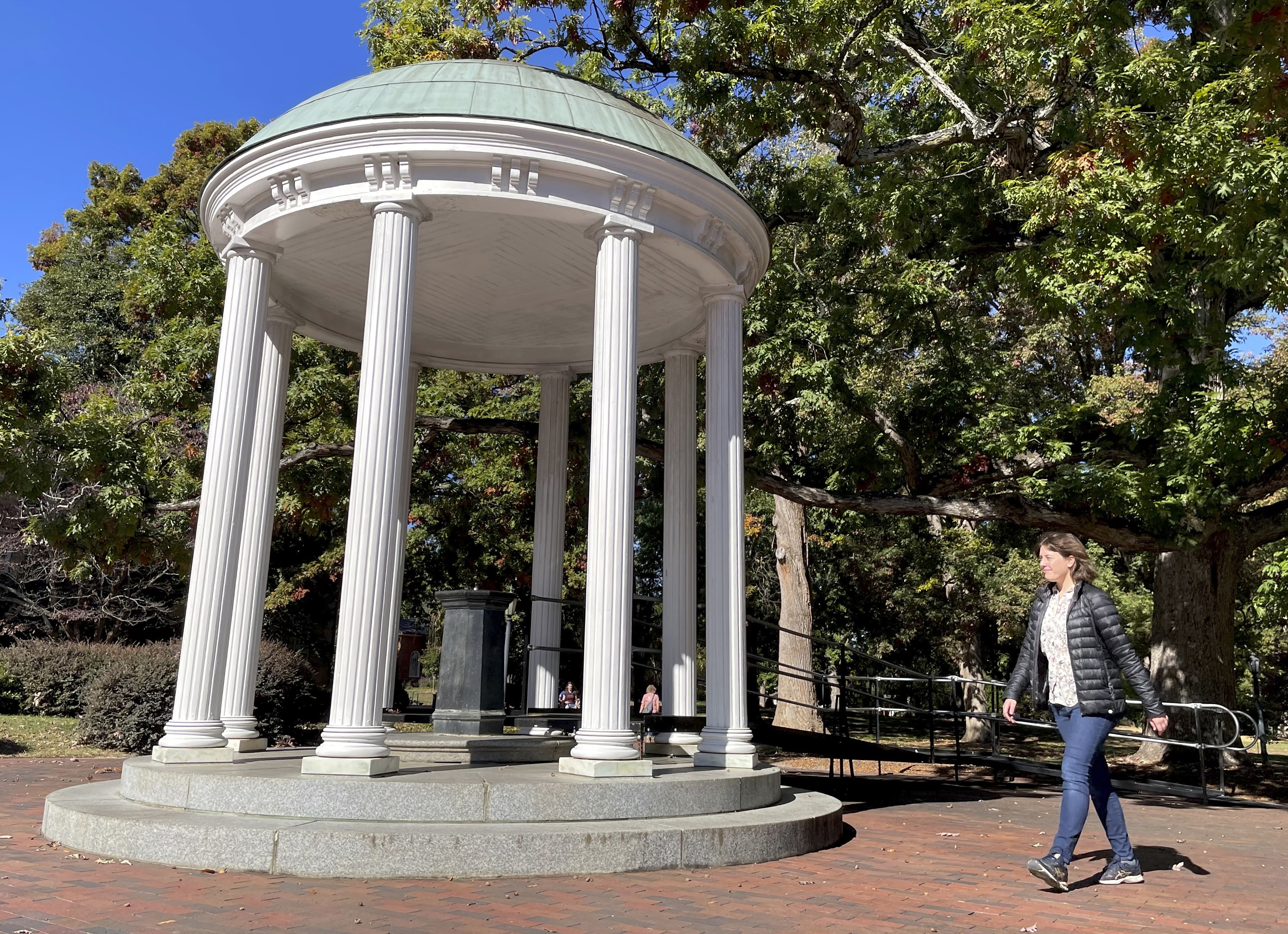 A student walks by the Old Well at the University of North Carolina at Chapel Hill, a rotunda and campus landmark at the southern end of McCorkle Place on Oct. 24. A Confederate statue known as Silent Sam statue once stood in the plaza before it was toppled by protesters in 2018. 