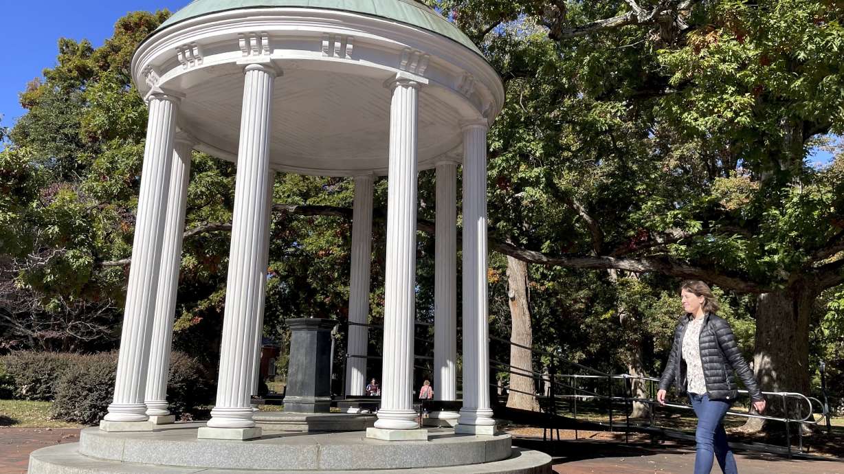 A student walks by the Old Well at the University of North Carolina at Chapel Hill, a rotunda and campus landmark at the southern end of McCorkle Place on Oct. 24. A Confederate statue known as Silent Sam statue once stood in the plaza before it was toppled by protesters in 2018.