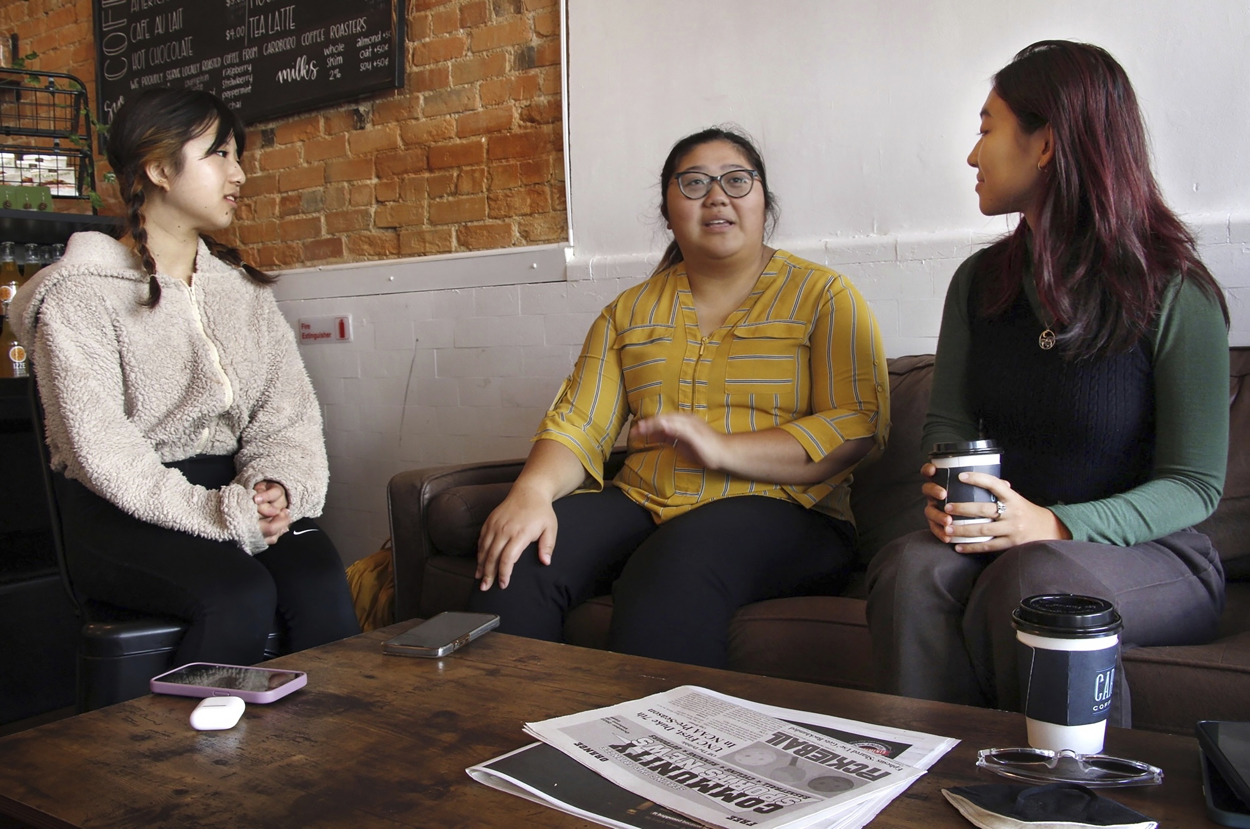 UNC for Affirmative Action co-directors Christina Huang, Joy Jiang and Adela Zhang discuss plans for an upcoming rally in support of affirmative action at Carolina Coffee Shop in Chapel Hill, N.C., on Oct. 24.