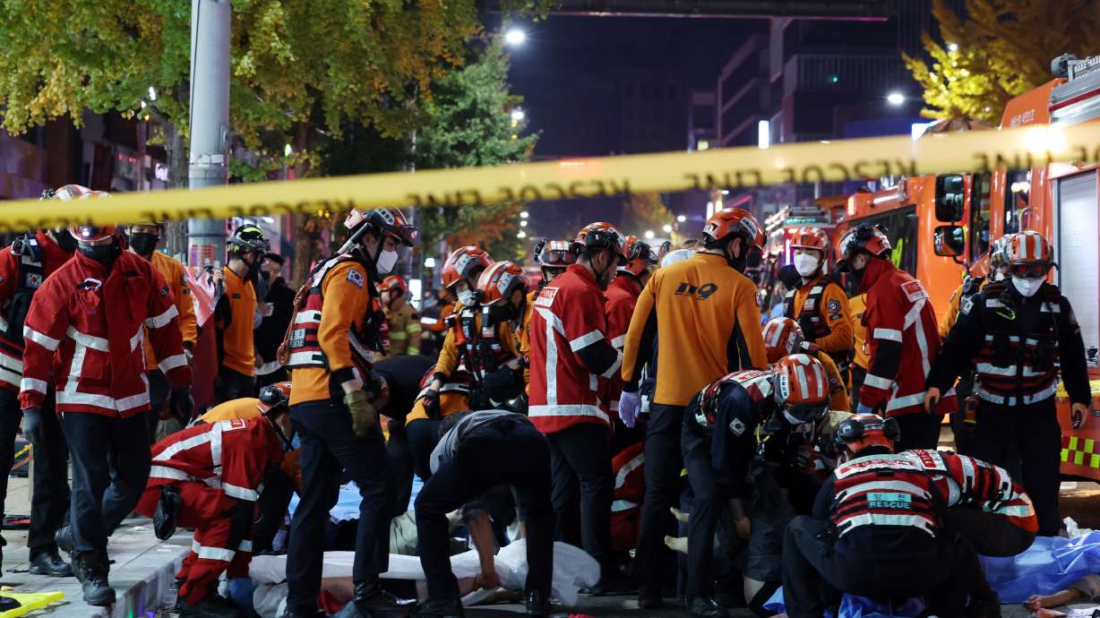 Rescue workers and firefighters work on the scene of a crushing accident in Seoul, South Korea, Saturday. A mass of mostly young people celebrating Halloween festivities in Seoul became trapped and crushed as the crowd surged into a narrow alley, killing at least 149 people and injuring 150 others in South Korea's worst disaster in years.