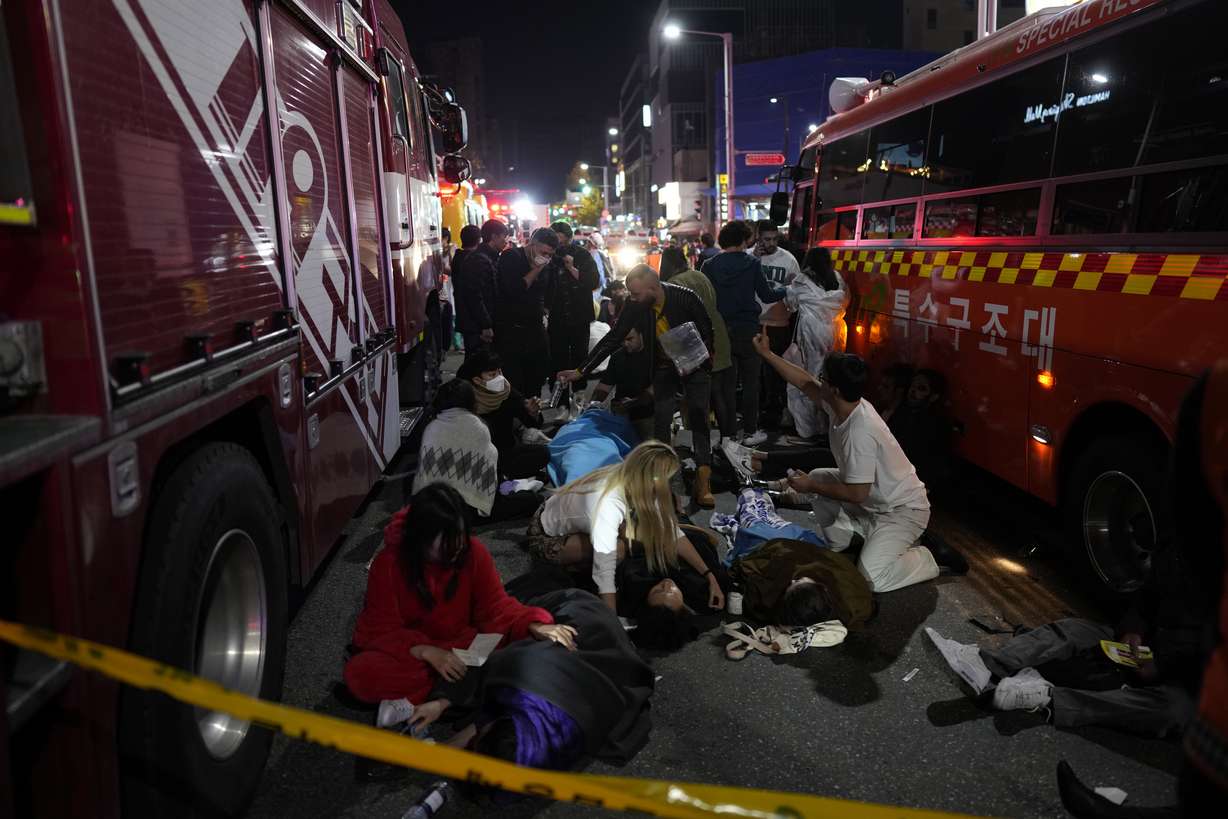 Injured people are helped on the street near the scene in Seoul, South Korea, early Sunday, Oct. 30. South Korean officials said around 50 people were in cardiac arrest and a number feared dead after being crushed by a large crowd pushing forward on a narrow street during Halloween festivities in the capital Seoul.