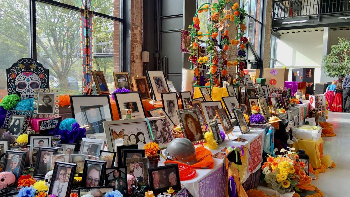 Photos of family members are placed on a Dia de los Muertos ofrenda, or altar, at Trolley Square in Salt Lake City on Saturday. Over 1,200 photos were placed on the altar, breaking a Guinness World Record for the most pictures of loved ones on a Dia de los Muertos altar.