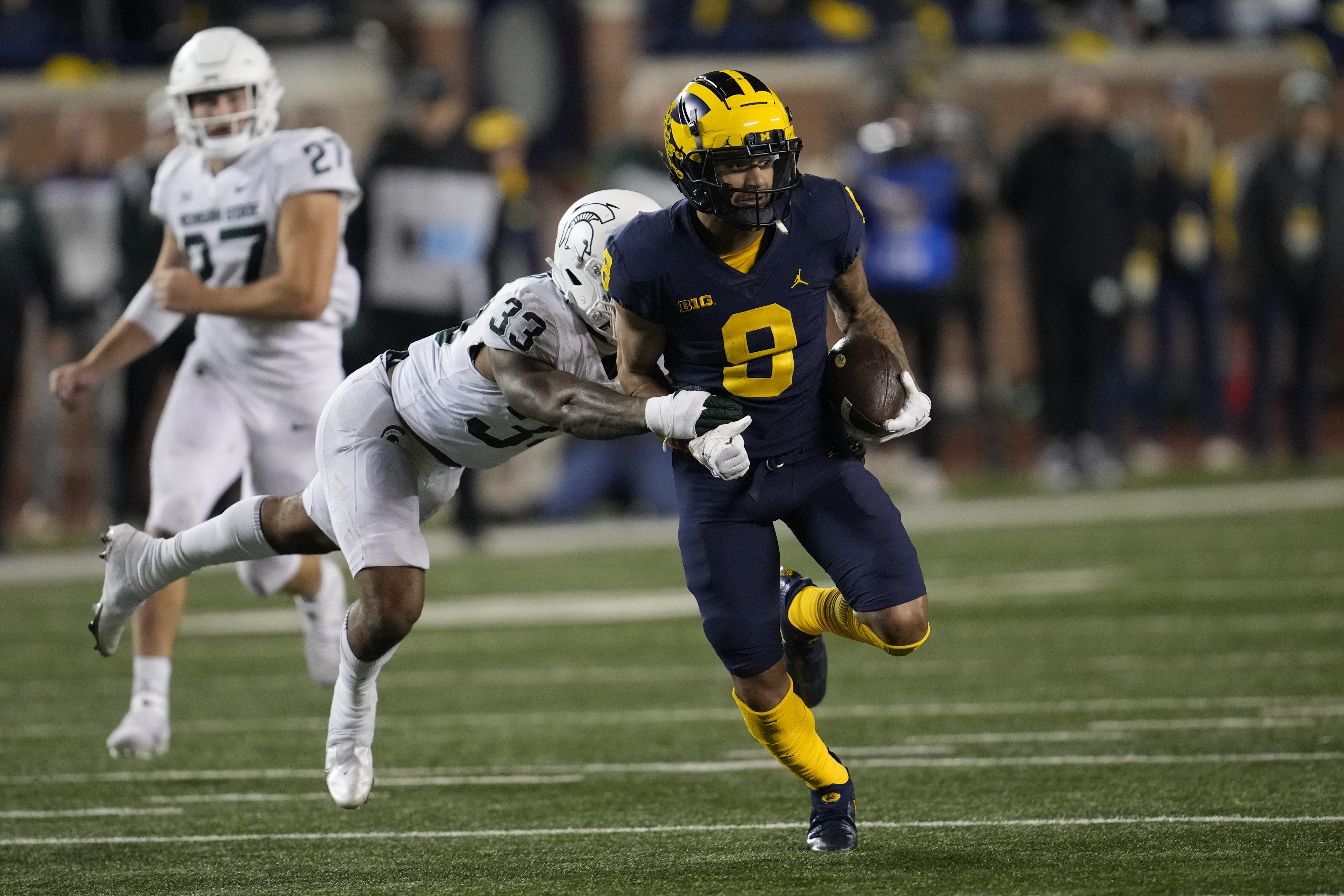 Michigan wide receiver Ronnie Bell (8) runs after a catch as Michigan State cornerback Kendell Brooks (33) defends in the second half of an NCAA college football game in Ann Arbor, Mich., Saturday, Oct. 29, 2022. 
