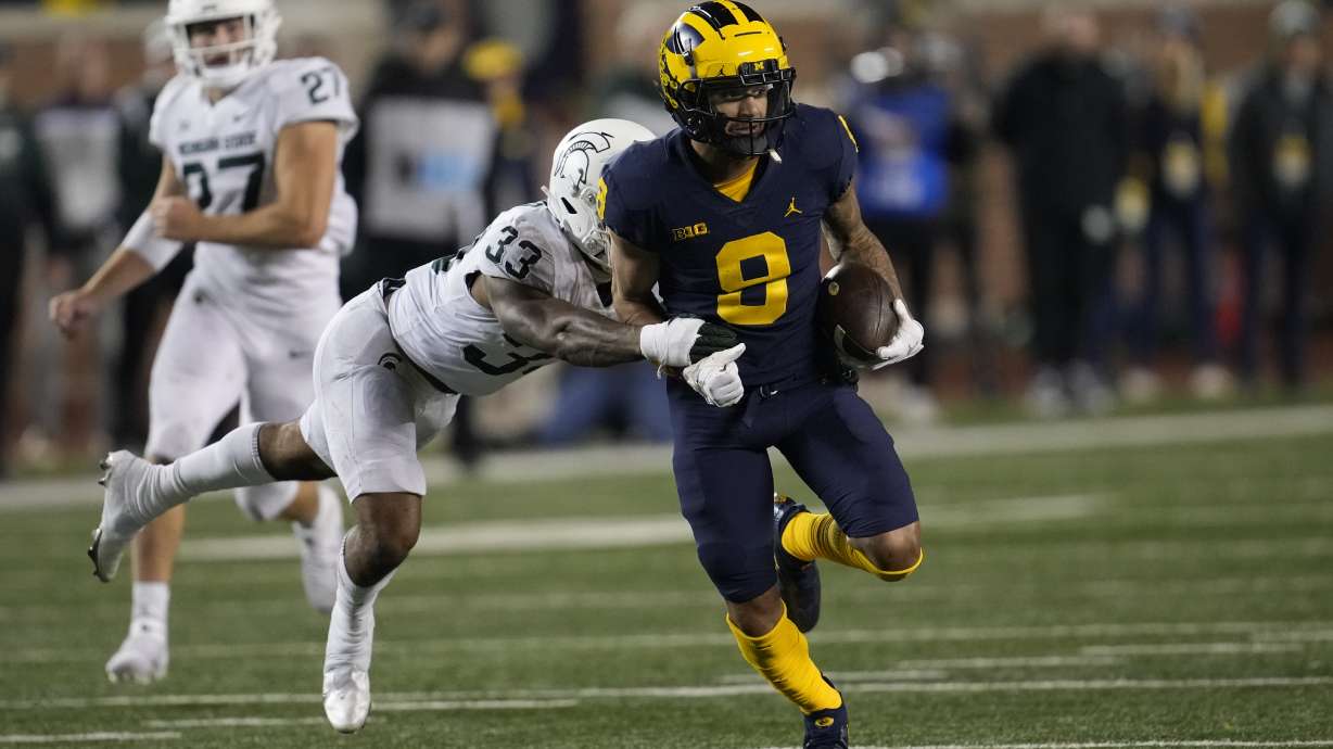 Michigan wide receiver Ronnie Bell (8) runs after a catch as Michigan State cornerback Kendell Brooks (33) defends in the second half of an NCAA college football game in Ann Arbor, Mich., Saturday, Oct. 29, 2022.