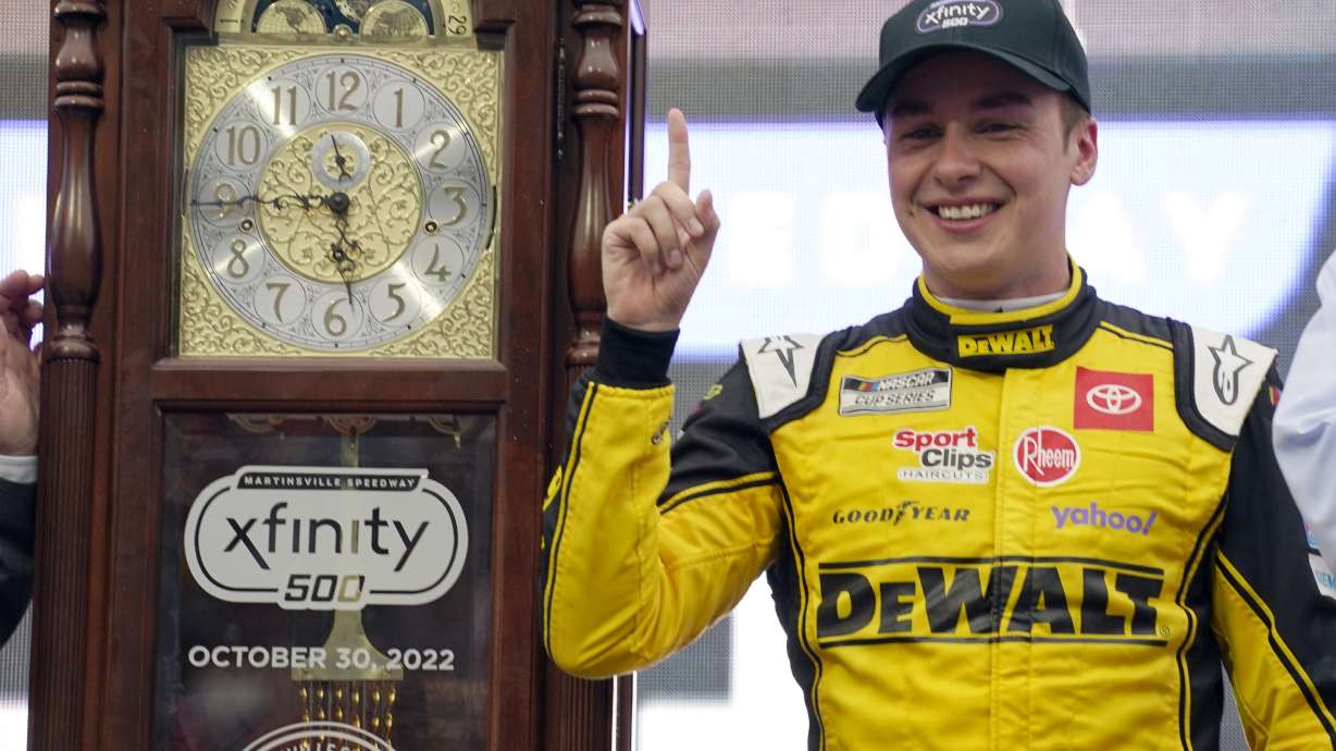 Christopher Bell (20) poses with the trophy in Victory Lane after winning a NASCAR Cup Series auto race at Martinsville Speedway, Sunday, Oct. 30, 2022, in Martinsville, Va.