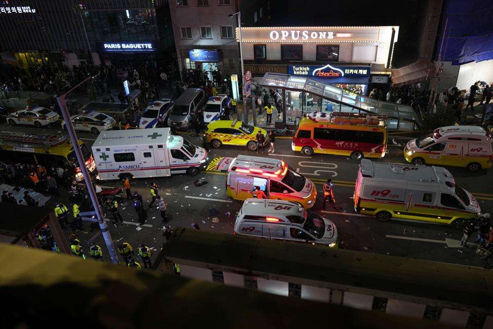 Ambulances and rescue workers gather near the scene in Seoul, South Korea, Sunday. At least 120 people were killed and 100 more were injured as they were crushed by a large crowd pushing forward on a narrow street during Halloween festivities in the capital of Seoul, South Korean officials said.