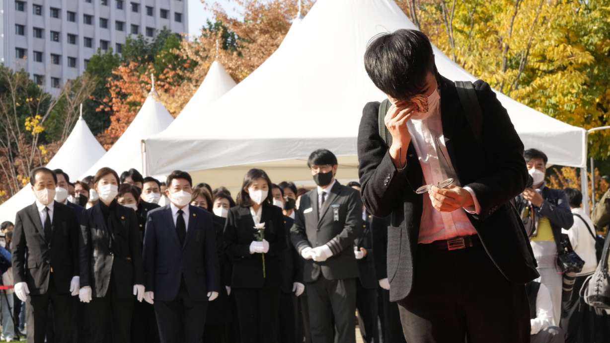 A mourner wipes his tear as he pays a silent tribute for victims of a deadly accident following Saturday night's Halloween festivities, at a joint memorial altar for victims at Seoul Square in Seoul, South Korea, Monday.