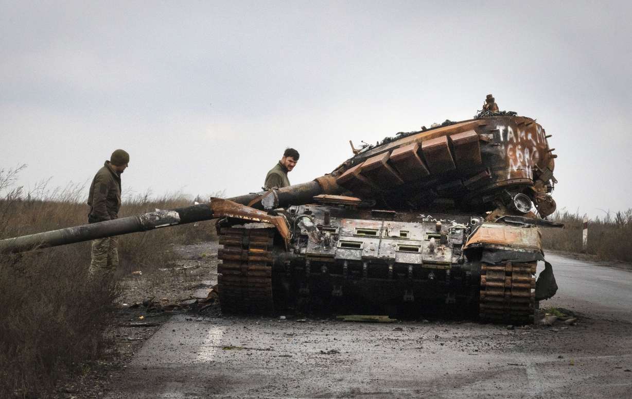 Ukrainian soldiers inspect a damaged Russian tank on a road near the recently retaken village of Kamianka, Kharkiv region, Ukraine, Sunday.
