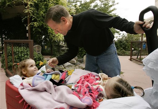 Jeff Warren, grandfather to formerly conjoined twins Kendra, left, and Maliyah Herrin, shows them a flower at Primary Children's Medical Center before heading for home Sunday, Sept. 17, 2006, in Salt Lake City. The two girls were separated last month. (AP Photo/Douglas C. Pizac)