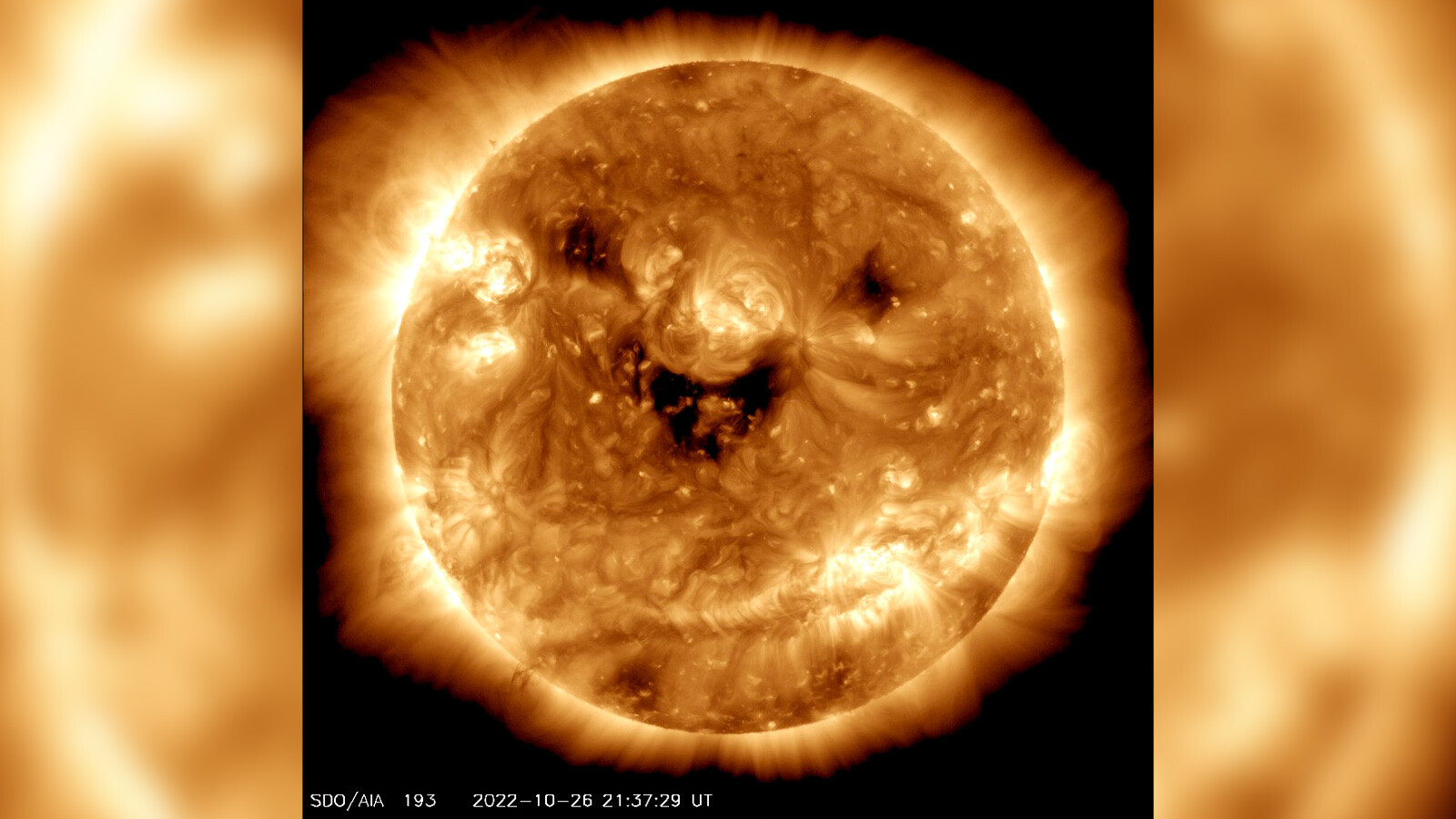 The NASA Solar Dynamics Observatory caught the sun "smiling." Seen in ultraviolet light, these dark patches are known as coronal holes and are regions where fast solar wind streams out into space.
