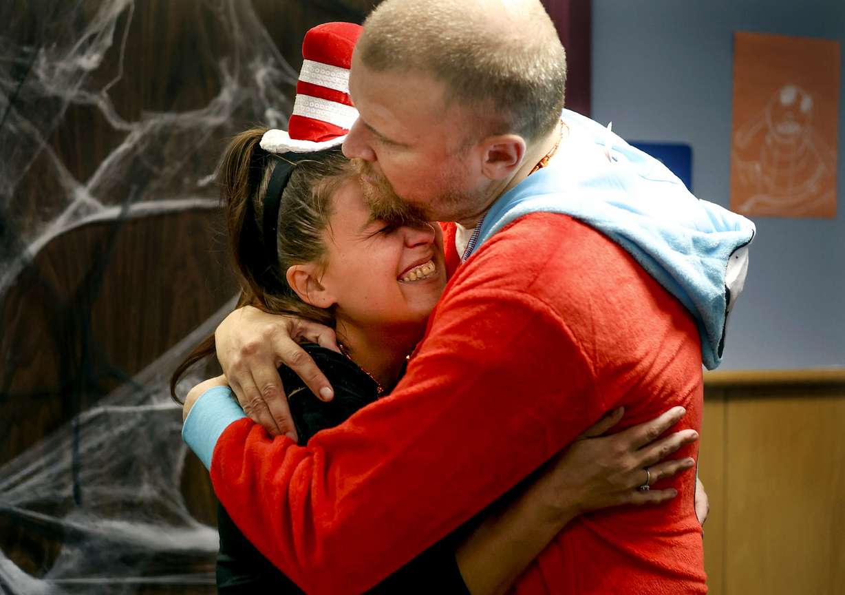 Lindzie Anderson Johnson, a staff member dressed as Cat in the Hat, gets a hug from Ryan, dressed as Thing 1, at the Together We Shine trick-or-treat event in Ogden on Monday.