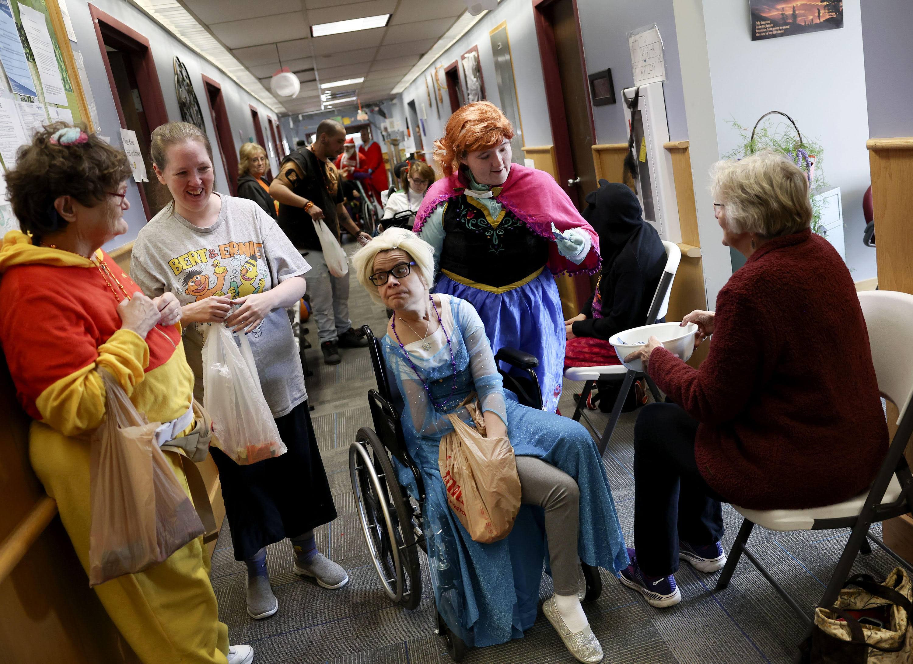 Tanna, center, dressed as Elsa from “Frozen,” and other clients of Together We Shine trick-or-treat at the center in Ogden on Monday. The services and support organization for adults with disabilities put on a Halloween trick-or-treat celebration for staff, clients and community members.