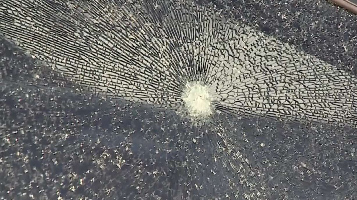 A car window is shown after shots were fired through it from a pellet gun. A man was arrested after police say he fired a pellet gun at a woman who had passed him in another car on I-15 on Monday.