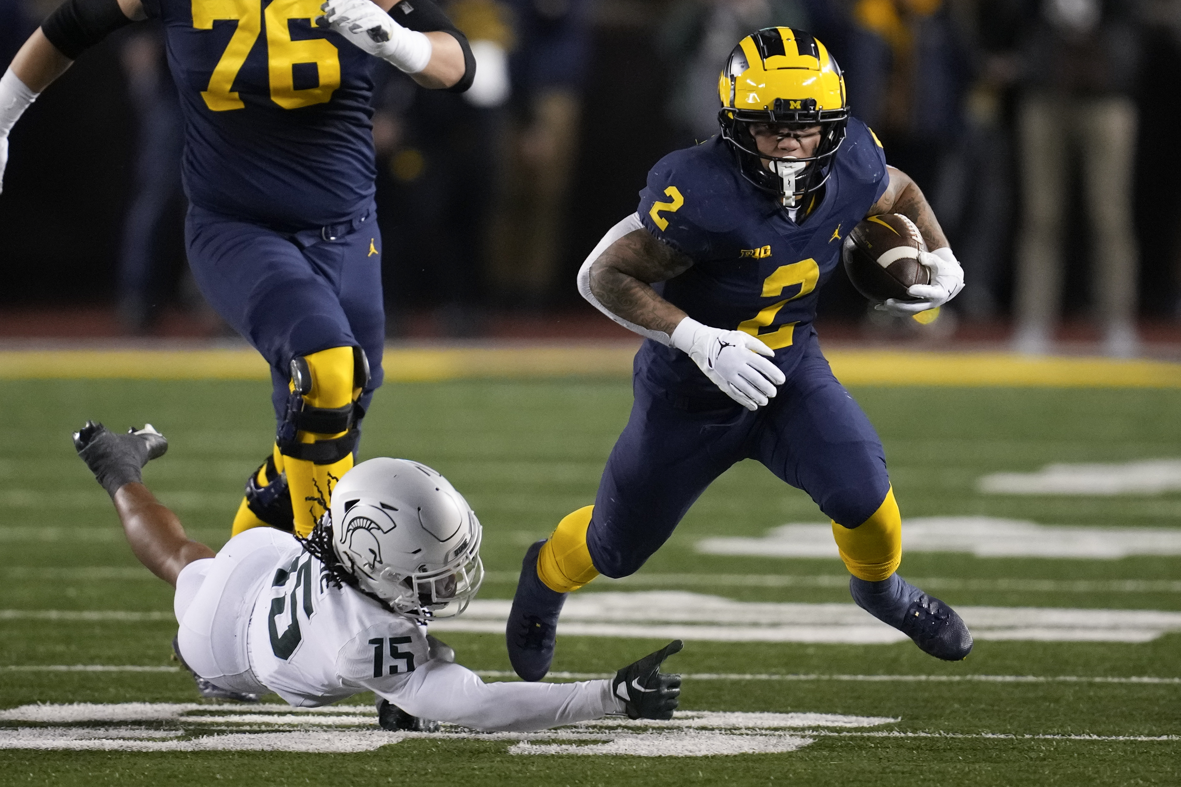 Michigan running back Blake Corum (2) escapes Michigan State safety Angelo Grose (15) in the first half of an NCAA college football game in Ann Arbor, Mich., Saturday, Oct. 29, 2022. 