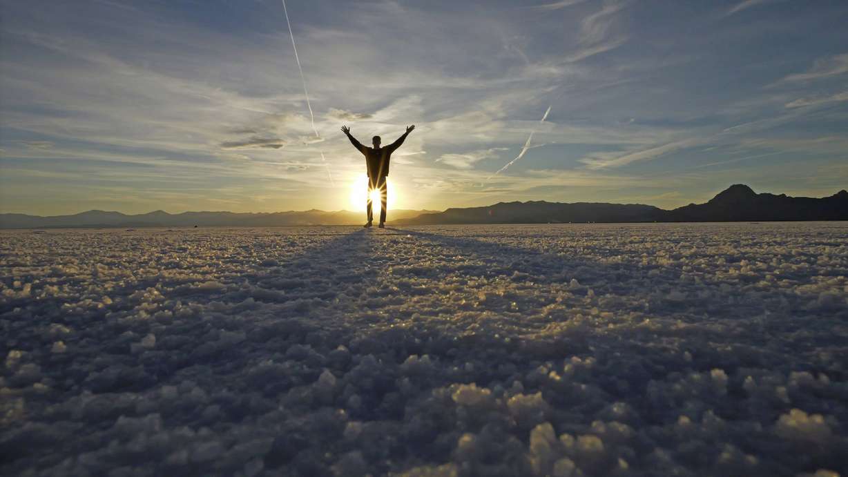 A visitor to Bonneville Salt Flats poses for photographs Oct. 8, near Wendover. The salt is thinning as climate change drags the West into its third decade of drought, yet it's unclear how that affects the seasonal flood patterns the landscape relies on to maintain its size and footprint.