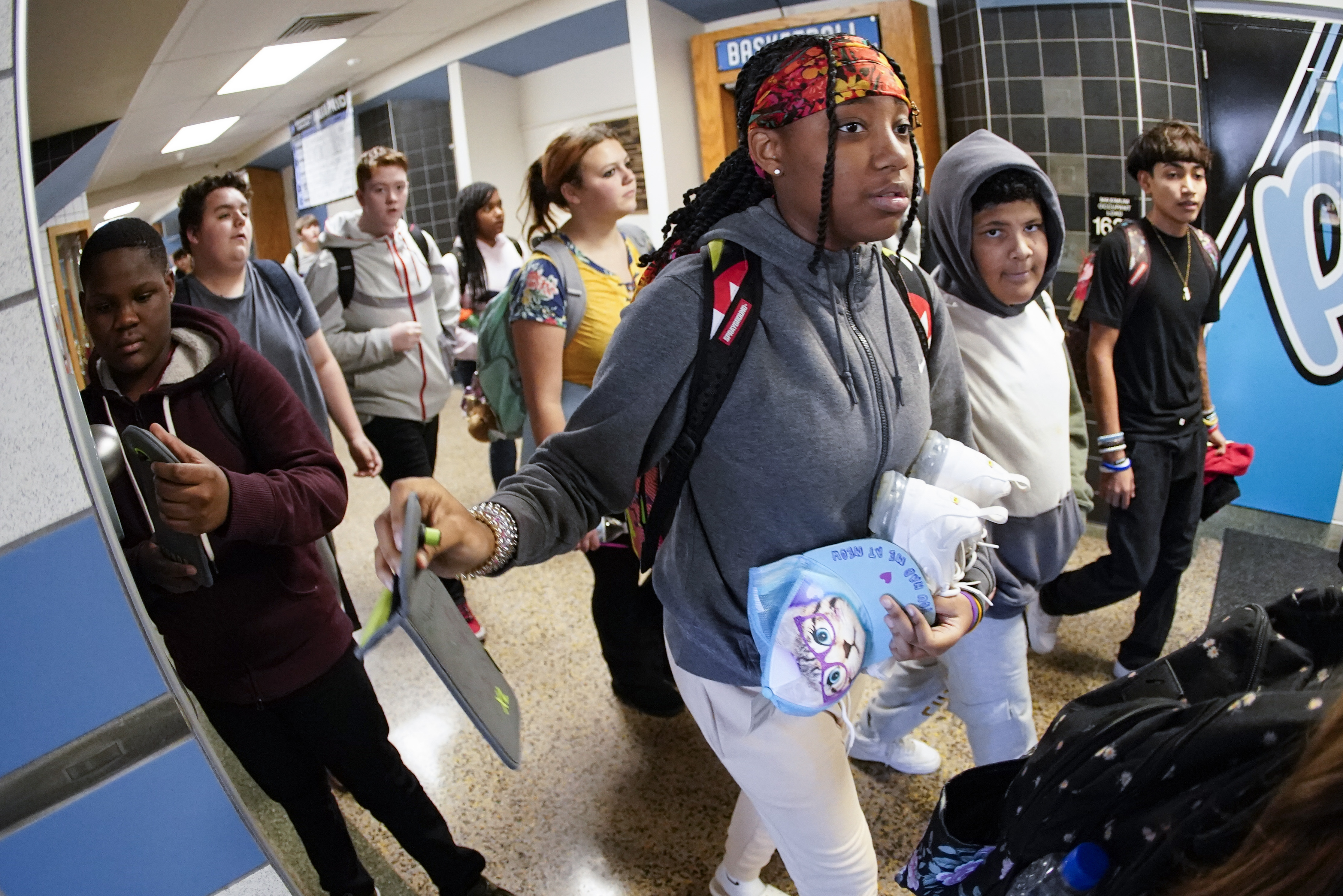 Students at the Washington Junior High School leaving classes for the day, use the unlocking mechanism to open the bags their cellphone were sealed in during the school day, Oct. 27, in Washington, Pa. Citing mental health, behavior and engagement as the impetus, many educators are updating cellphone policies, with a number turning to pouches. 