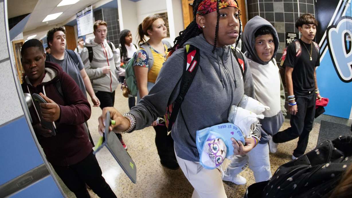 Students at the Washington Junior High School leaving classes for the day, use the unlocking mechanism to open the bags their cellphone were sealed in during the school day, Oct. 27, in Washington, Pa. Citing mental health, behavior and engagement as the impetus, many educators are updating cellphone policies, with a number turning to pouches.