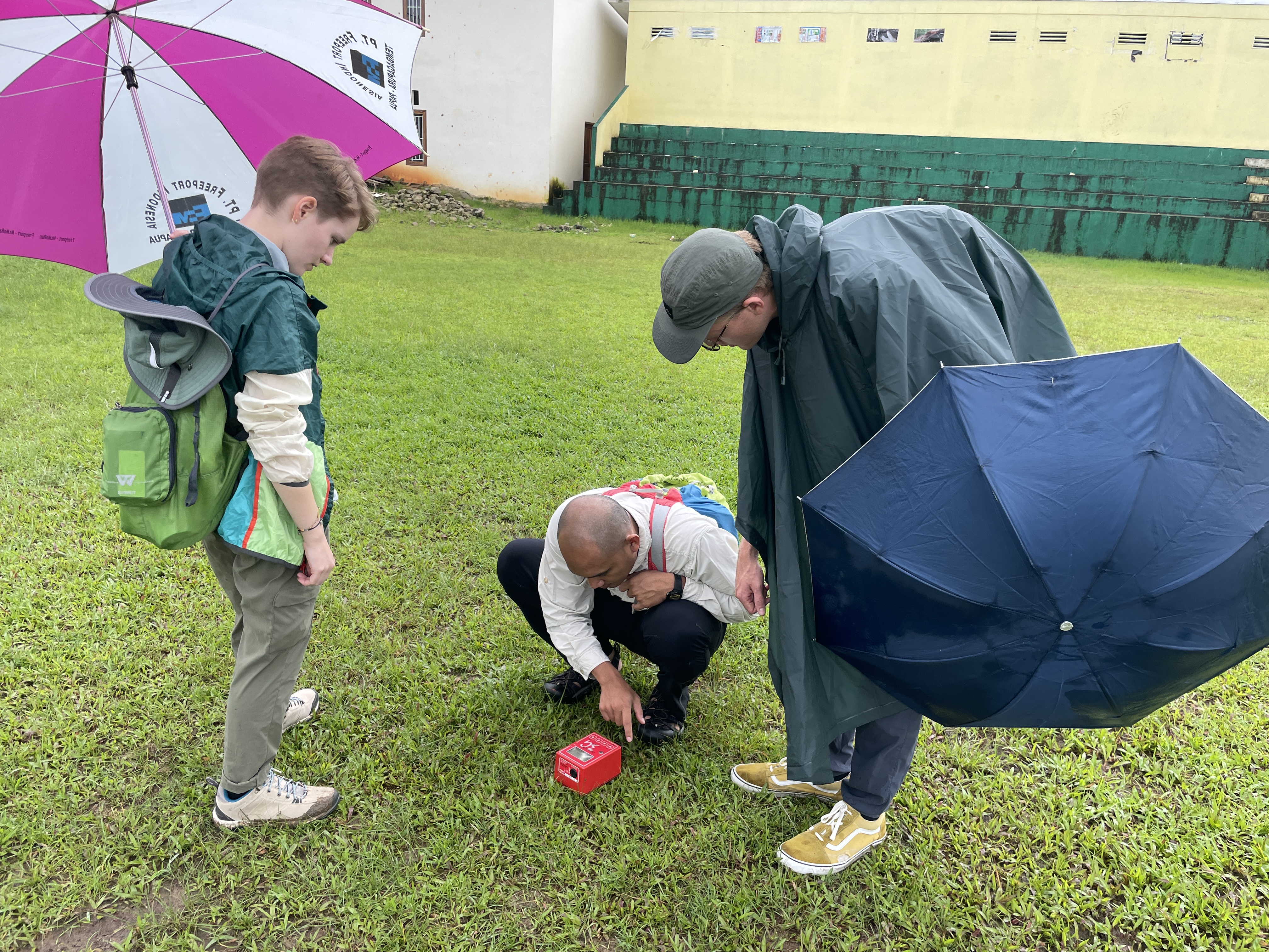 Shayna Orme, Brierton Sharp, and Hanif Sulaeman calibrate the HVSR instrument to collect data on the subsurface of Ambon, Indonesia, in August.