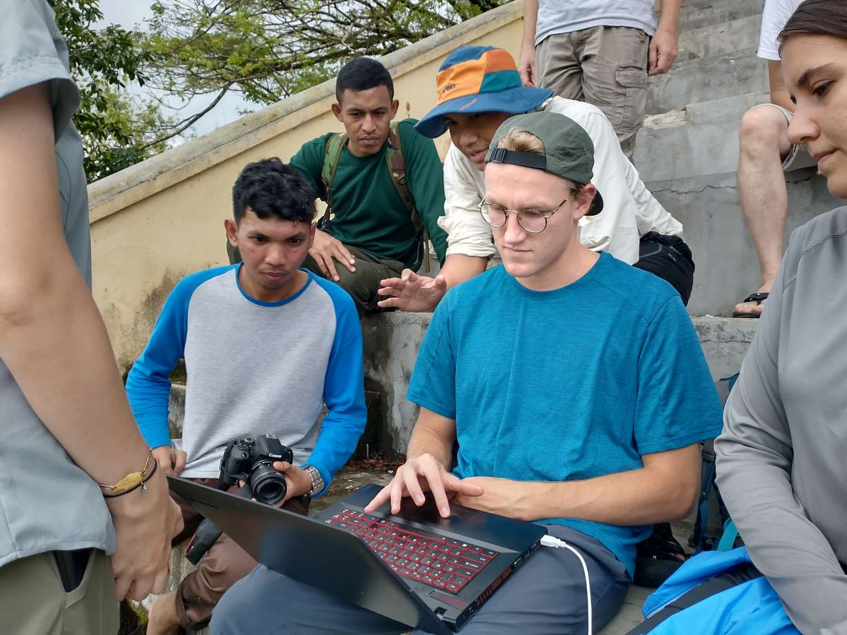 Brierton Sharp and Hanif Sulaeman explain data to local college students while the team takes measurements at the University of Pattimura. Sharp and two other students visited Ambon, Indonesia, in August to implement risk reduction strategies in communities.