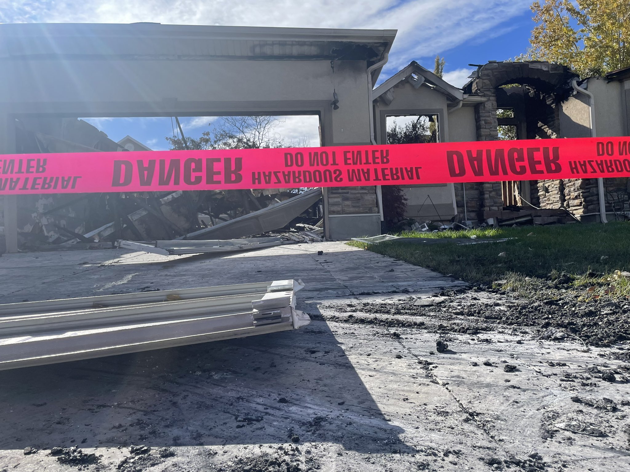 Investigators were still working to determine the cause of a house fire Friday, one day after an explosion and flames destroyed a home and damaged another in West Jordan.