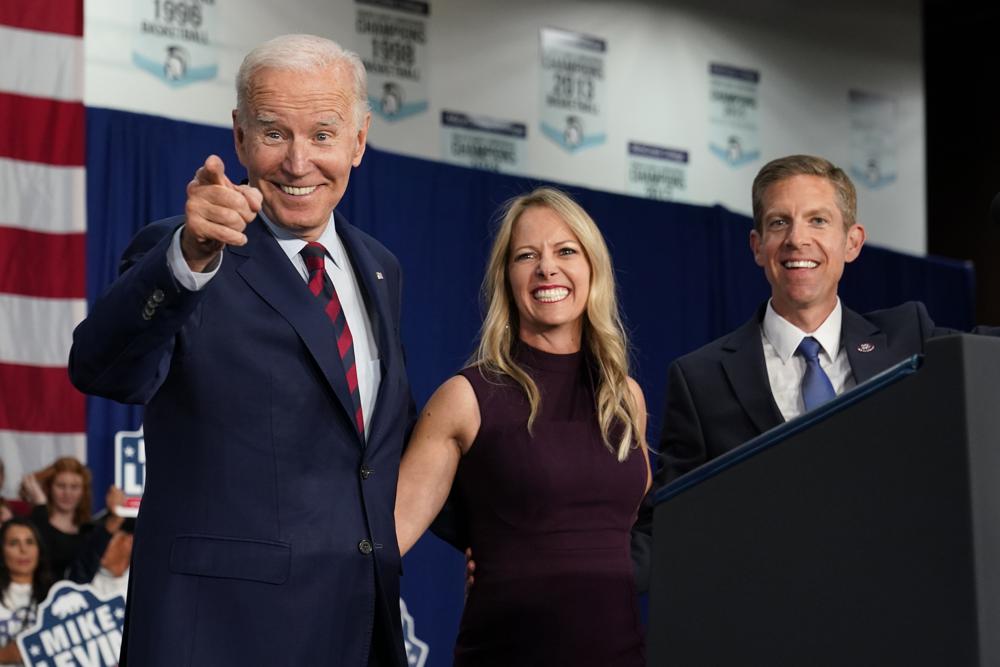 President Joe Biden stands on stage with Rep. Mike Levin, D-Calif., and his wife Chrissy, after Biden spoke at a campaign rally Thursday in San Diego.