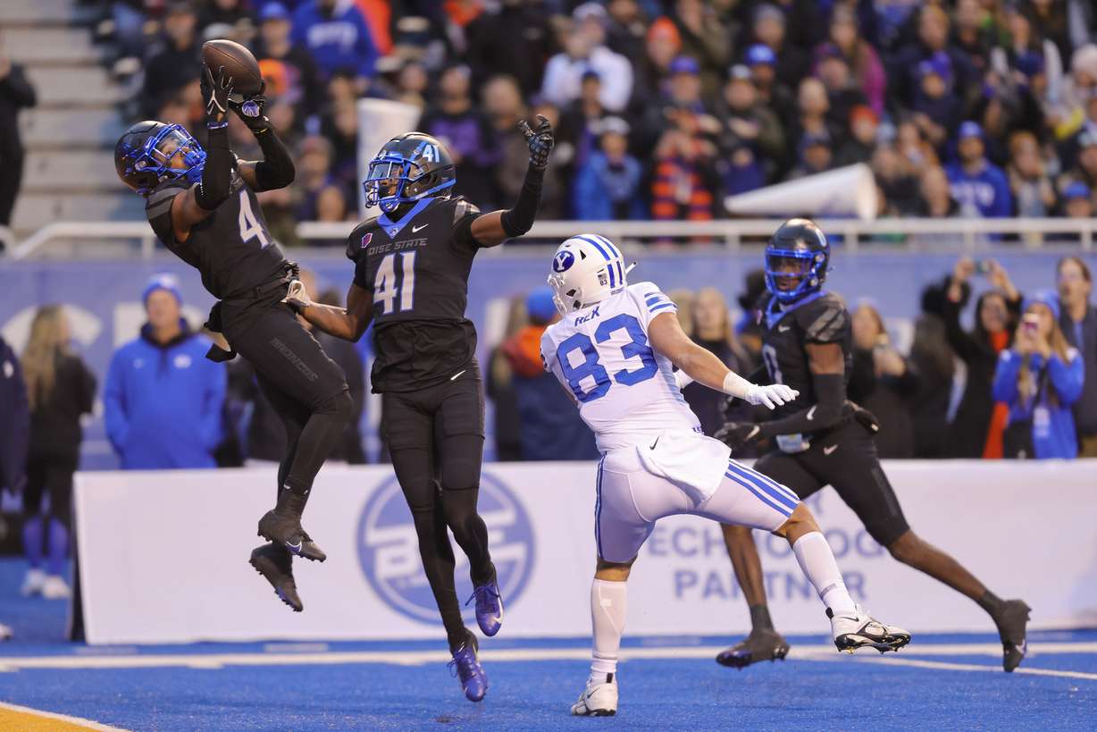 Boise State safety Rodney Robinson (4) catches the ball for an interception on a throw to BYU tight end Isaac Rex (83) in front of Boise State cornerback Jaylen Clark (41) in the first half of an NCAA college football game, Saturday, Nov. 5, 2022, in Boise, Idaho.