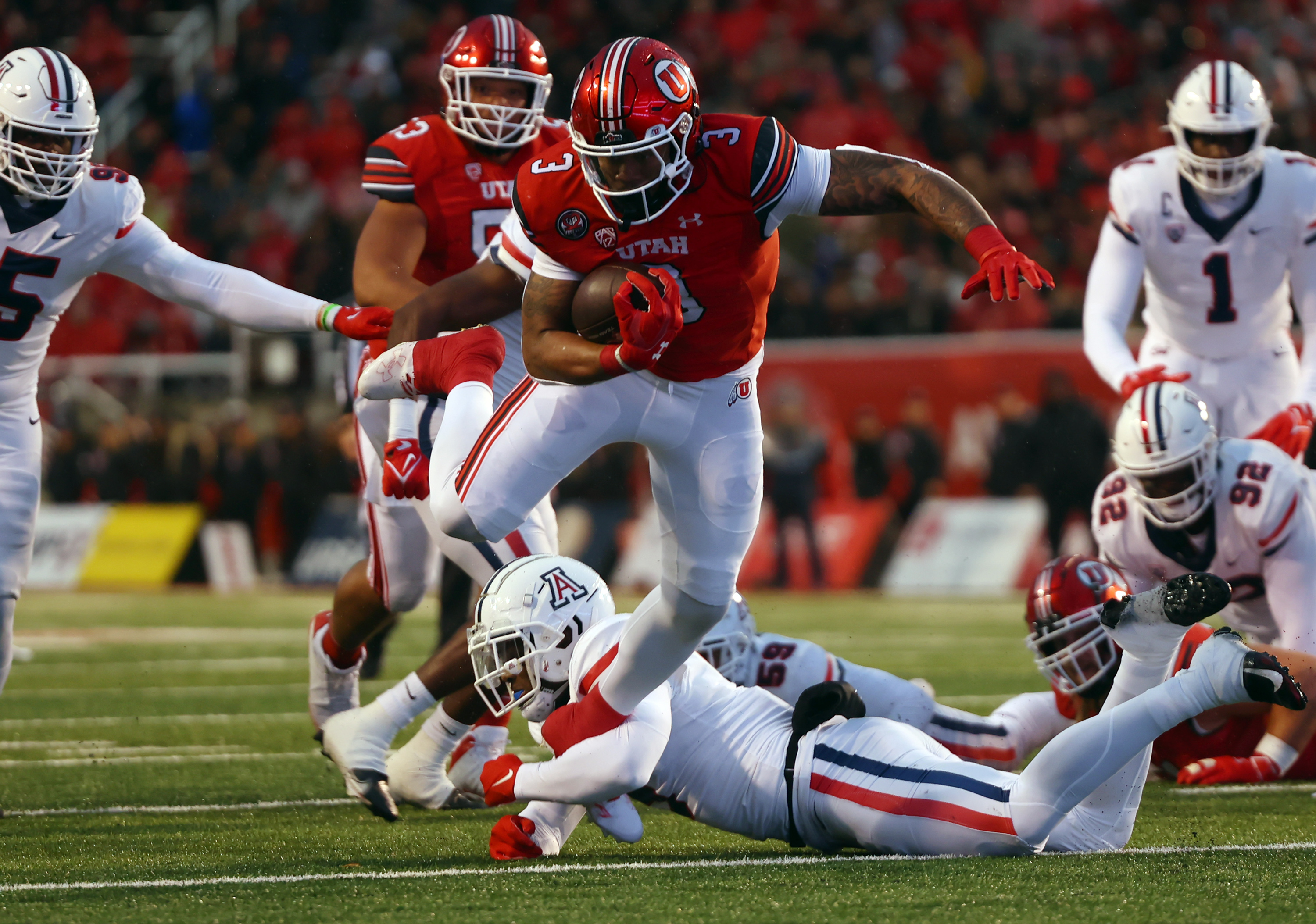 Utah Utes running back Ja'Quinden Jackson (3) is tripped up by Arizona Wildcats safety Christian Young (5) as Utah and Arizona play at Rice Eccles Stadium in Salt Lake City on Saturday, Nov. 5, 2022.