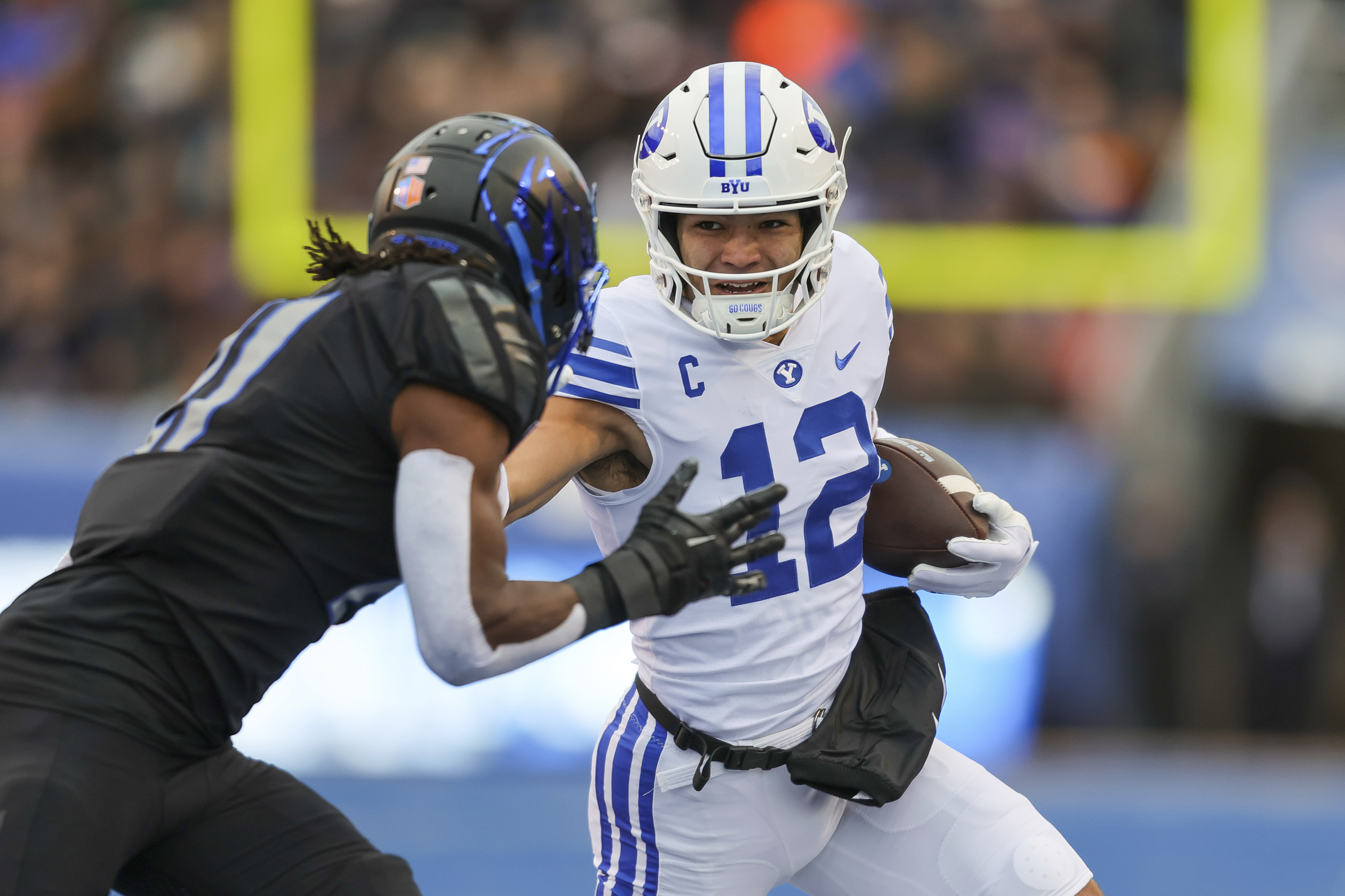BYU wide receiver Puka Nacua (12) stiff-arms Boise State cornerback Tyreque Jones, left, after a catch in the first half of an NCAA college football game, Saturday, Nov. 5, 2022, in Boise, Idaho.