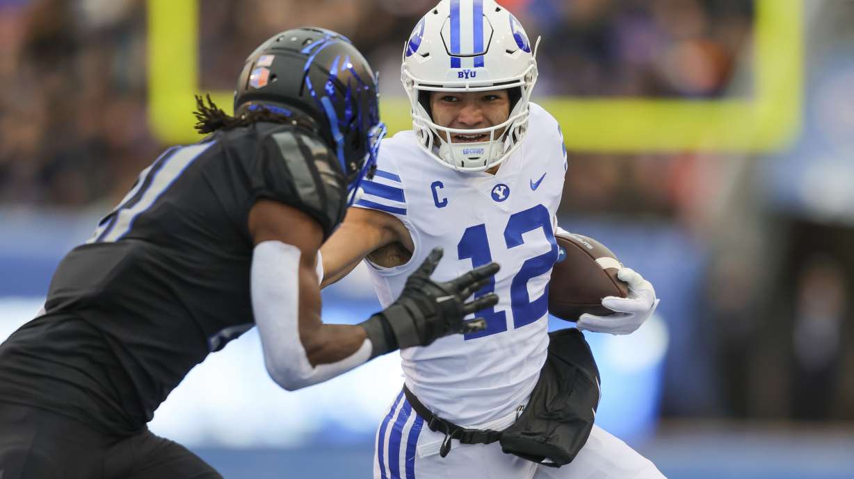 BYU wide receiver Puka Nacua (12) stiff-arms Boise State cornerback Tyreque Jones, left, after a catch in the first half of an NCAA college football game, Saturday, Nov. 5, 2022, in Boise, Idaho.