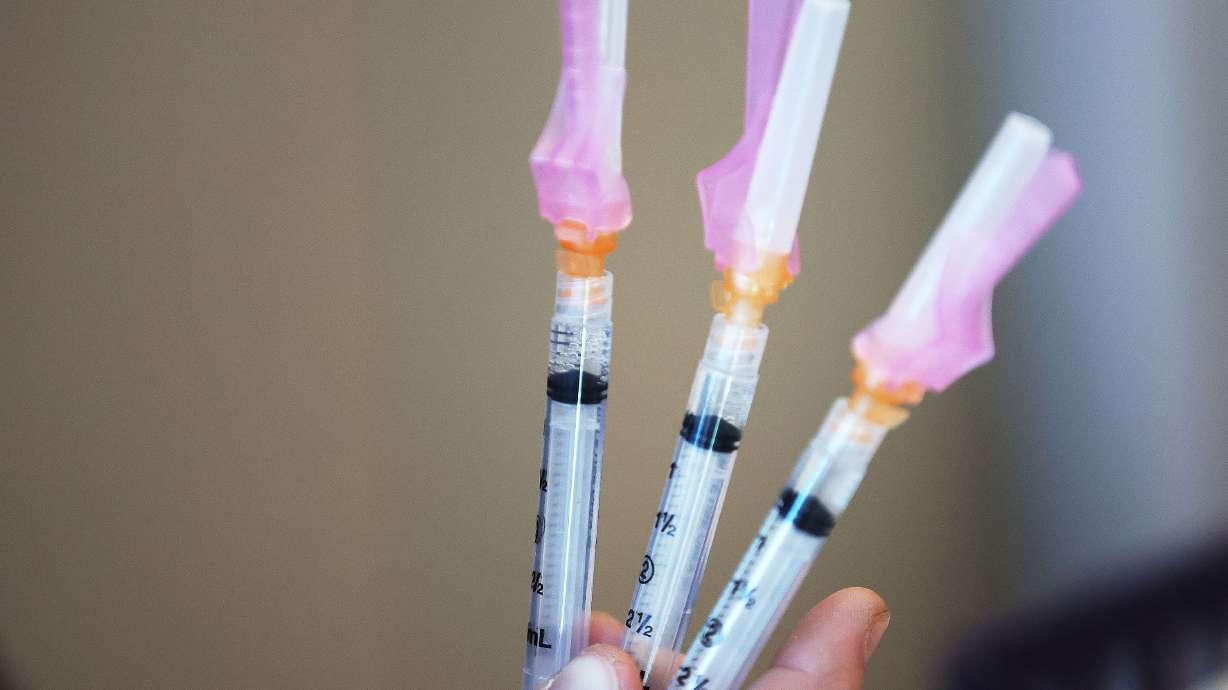 Flu vaccines are prepared at the Community Health Center Neighborhood Clinic in Salt Lake City on Oct. 28. With COVID-19 booster shots expected to become as routine as an annual flu vaccine, a single shot combining both is currently being tested.