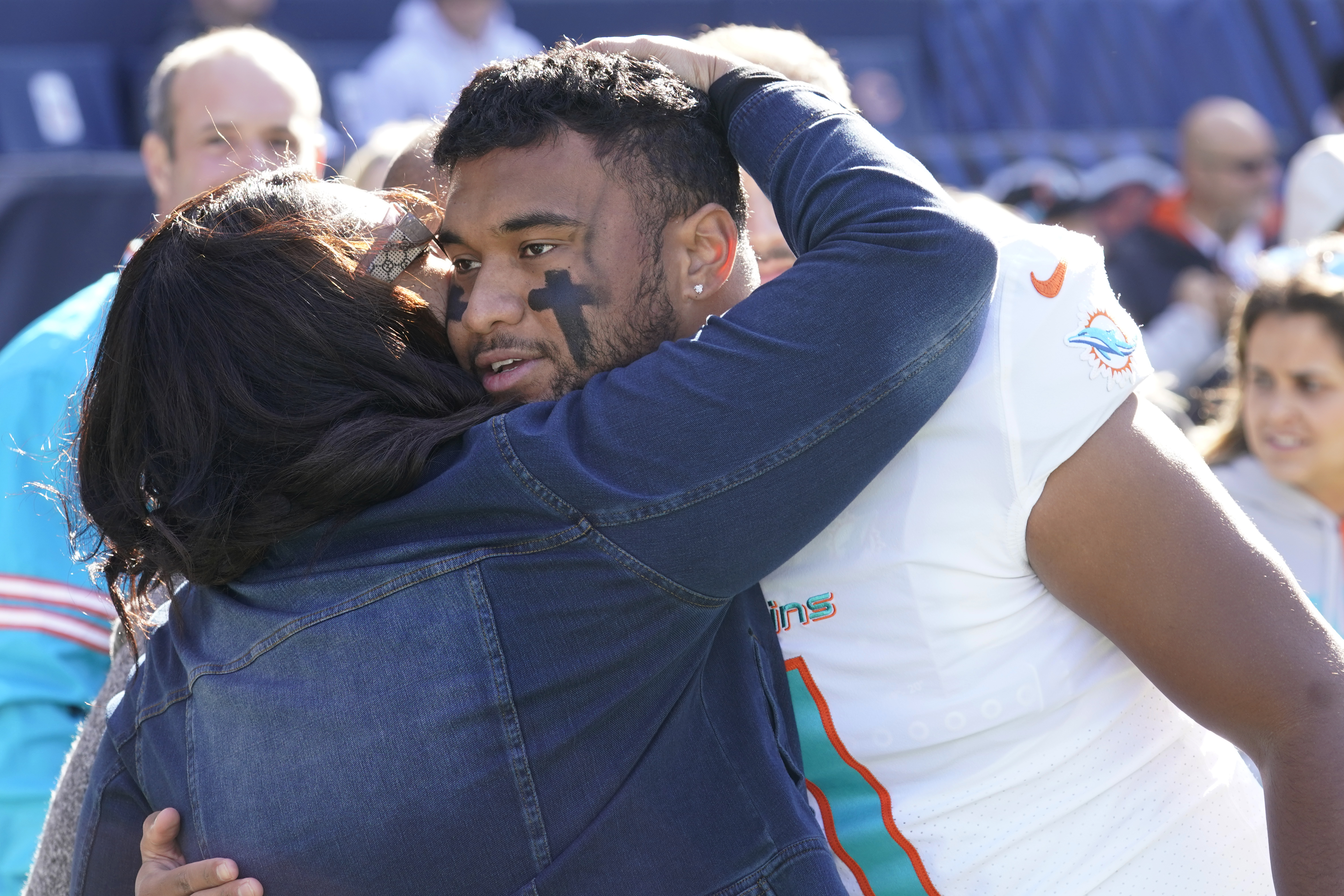 Miami Dolphins quarterback Tua Tagovailoa gets a hug from his mother Diane Tagovailoa before the start of an NFL football game against the Chicago Bears, Sunday, Nov. 6, 2022 in Chicago.