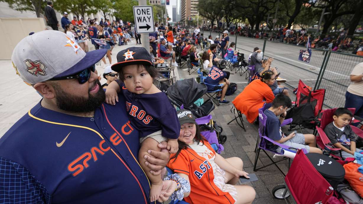 Luis Varela holds his 10-month-old son Joaquin as fans wait for a victory parade for the Houston Astros' World Series baseball championship Monday, Nov. 7, 2022, in Houston.