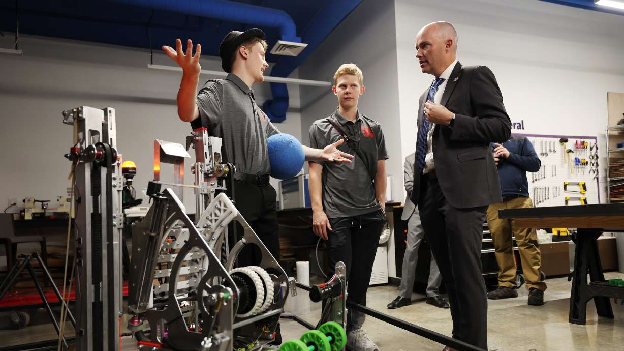 Timothy Holt, left, and Marshall Hansen, show off their robot Mantis to Gov. Spencer Cox at the Utah STEM Action Center in South Salt Lake on Monday. The two students are from a group called Icarus Innovated at Alta High School in Sandy. The governor declared Utah’s first “Week of STEM” during an event at the center.