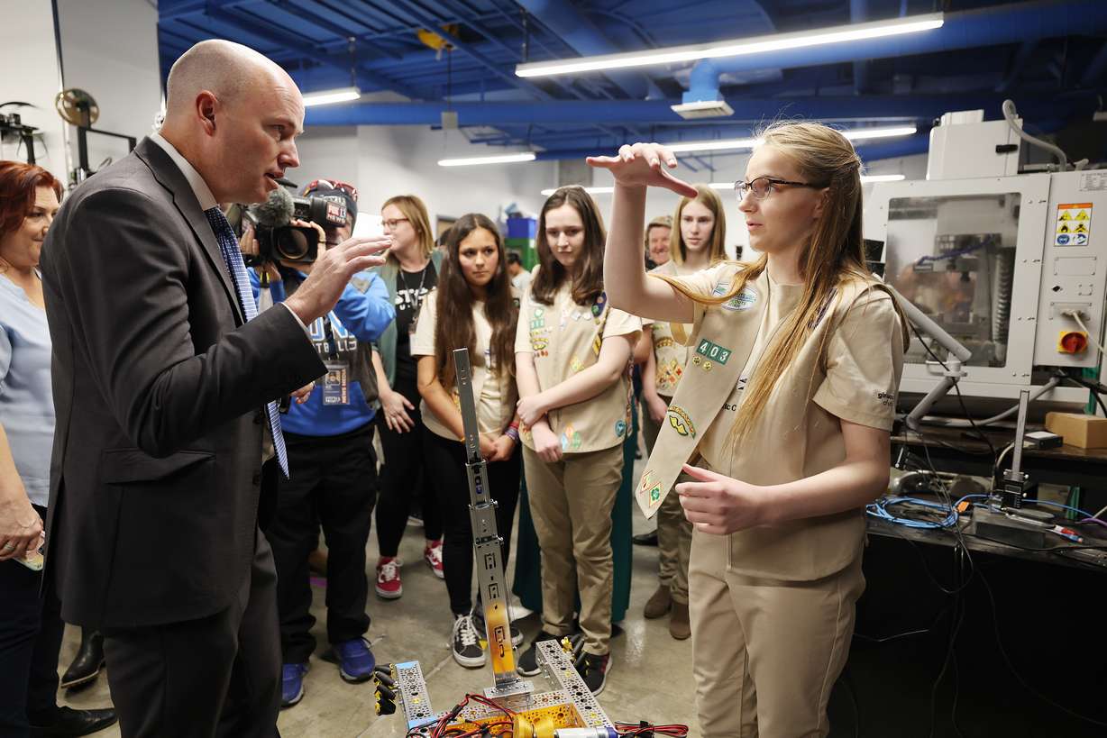 Gov. Spencer Cox, left, talks with Paige Manning-Duncan from the Girls Scouts FTC program as she explains their robot after he declared Utah’s first “Week of STEM” at an event at the Utah STEM Action Center in South Salt Lake on Monday.