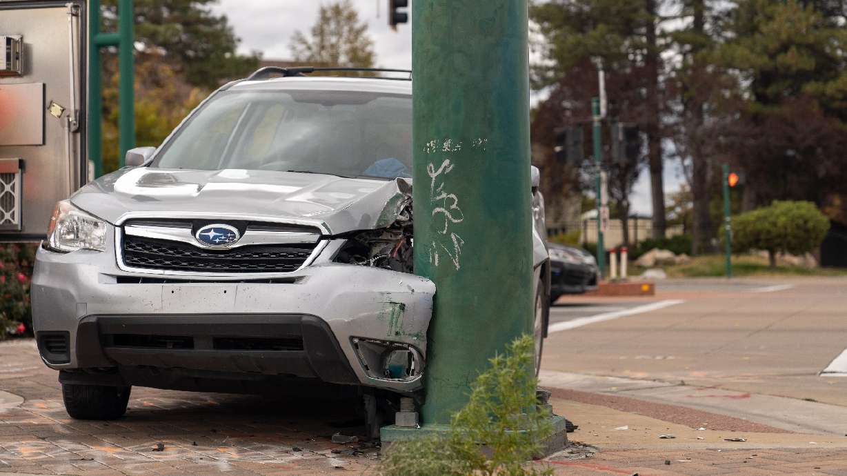 Police say a man has been arrested after crashing a stolen SUV into a traffic pole, and then running from officers Monday morning.