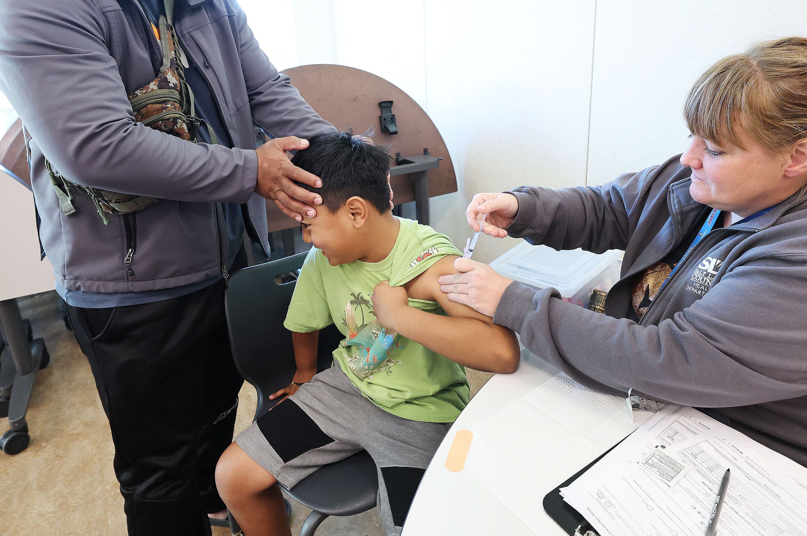 Steifi Otup holds his son Sitoshy Otup, 8, while he gets his flu vaccine at the Community Health Center Neighborhood Clinic in Salt Lake City on Oct. 28.