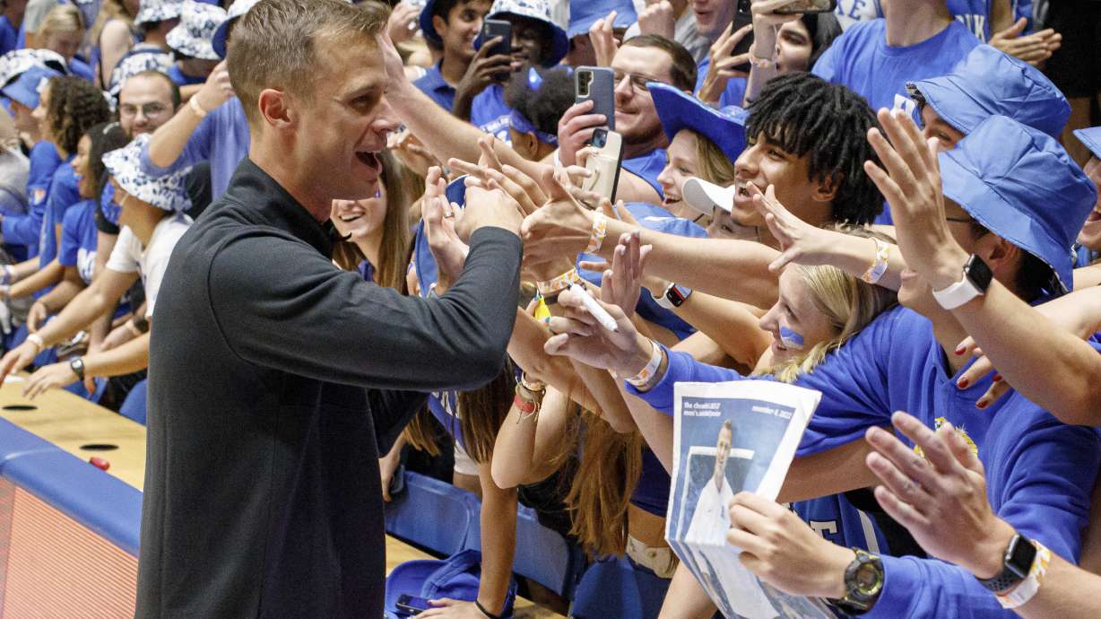 Duke head coach Jon Scheyer greets fans in the Duke student section after earning his first win as head coach of the Blue Devils in an NCAA college basketball game against Jacksonville in Durham, N.C., Monday, Nov. 7, 2022.