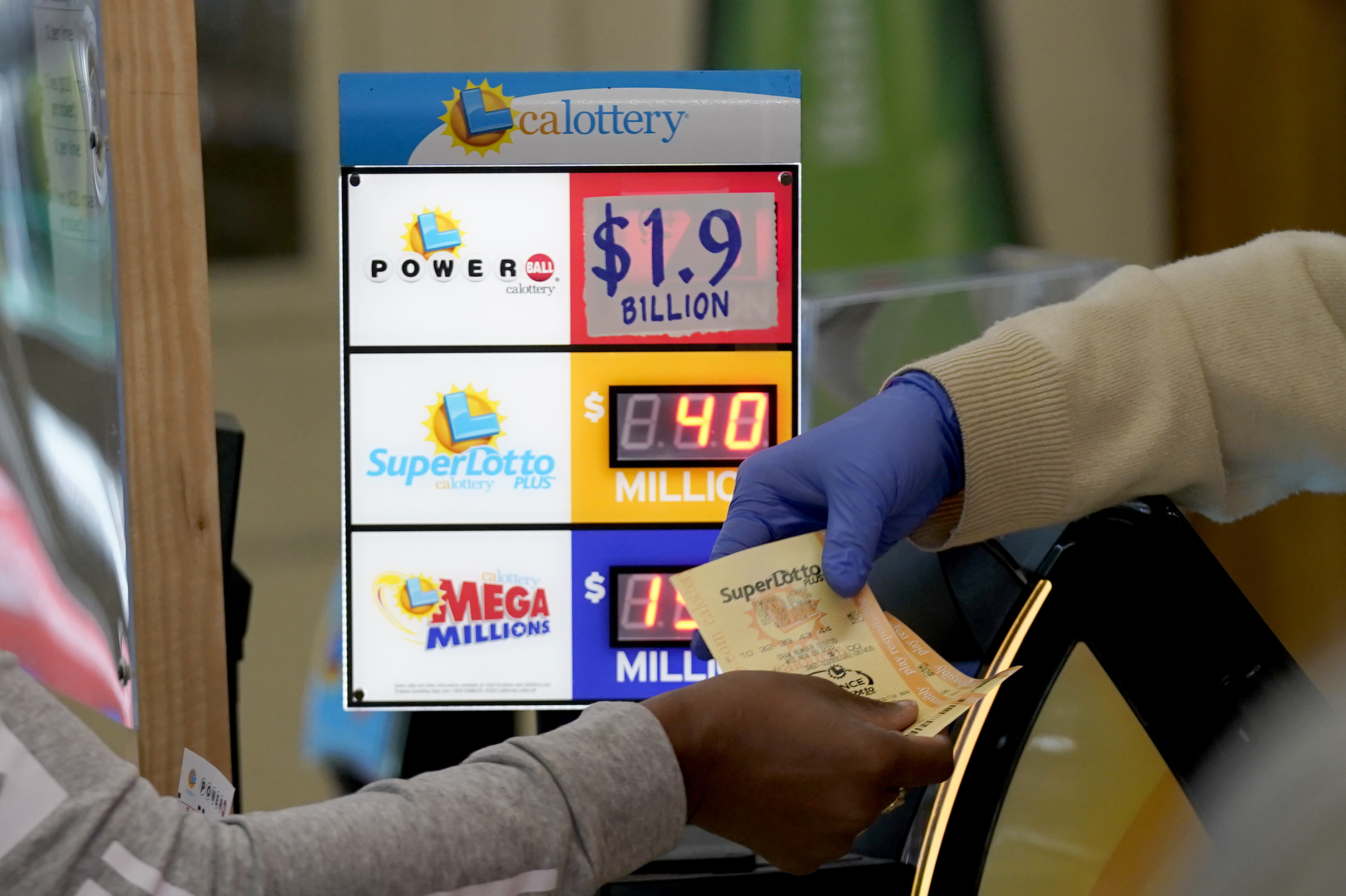 A customer is handed Powerball tickets purchased at Lichine's Liquor & Deli in Sacramento, Calif., Monday. Someone who bought a Powerball ticket in Altadena, California, has won a record $2.04 billion Powerball jackpot.