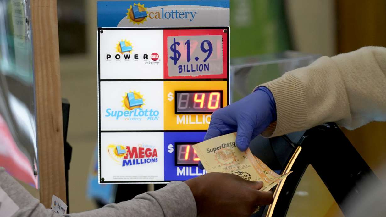 A customer is handed Powerball tickets purchased at Lichine's Liquor & Deli in Sacramento, Calif., Monday. Someone who bought a Powerball ticket in Altadena, California, has won a record $2.04 billion Powerball jackpot.