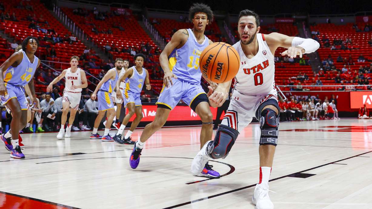 Utah Runnin’ Utes Gavin Baxter (0) looses the ball while Long Island Sharks C.J. Delancy (15) stands behind during a game at Jon M. And Karen Huntsman Basketball Facility in Salt Lake City on Monday, Nov. 7, 2022.