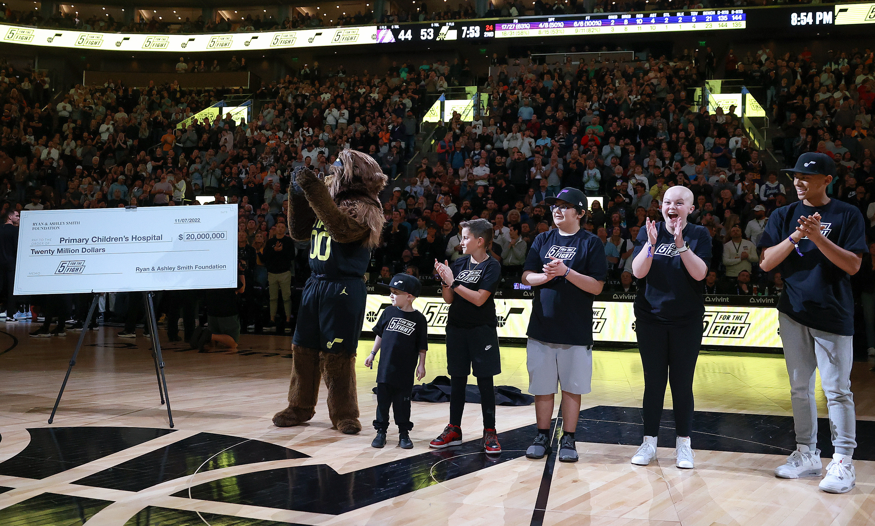 Jazz Bear unveils a a $20 million check from the Ryan and Ashley Smith Foundation to Intermountain Primary Children’s Hospital during a break in an NBA game between the Utah Jazz and the Los Angeles Lakers at the Vivint Arena in Salt Lake City on Monday, Nov. 7, 2022. Intermountain Primary Children’s Hospital cancer patients Tyson Lazenby, 4, Noah Reeb, 11, Cohen Jones, 16, Samantha “Mantha” Corey, 16, and Afu Fiefia, 16, cheer.
