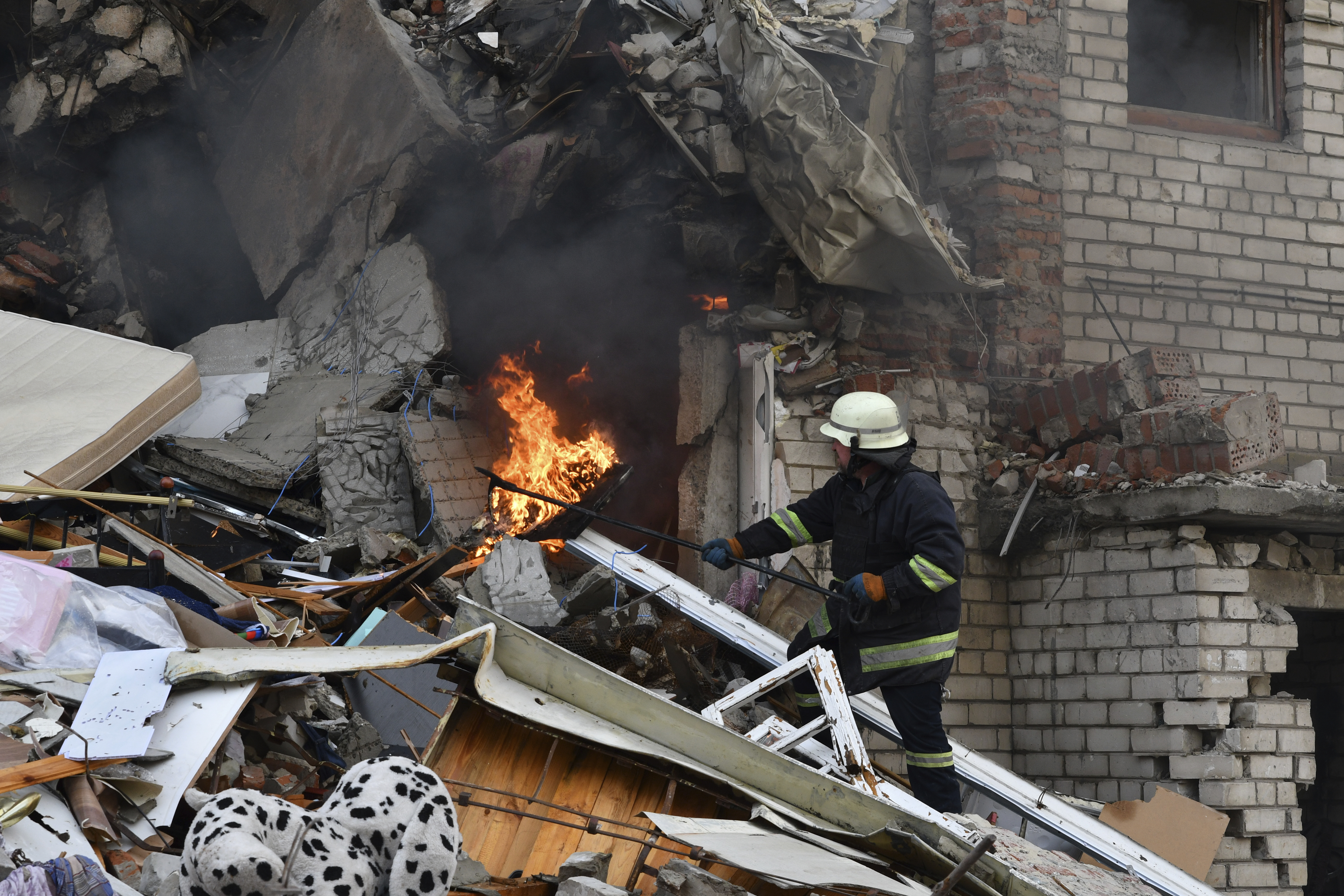 A firefighter works at the scene of a damaged residential building after Russian shelling in the liberated Lyman, Donetsk region, Ukraine, Monday. Ukraine's president has suggested he's open to peace talks with Russia while sticking to Kyiv's demands.