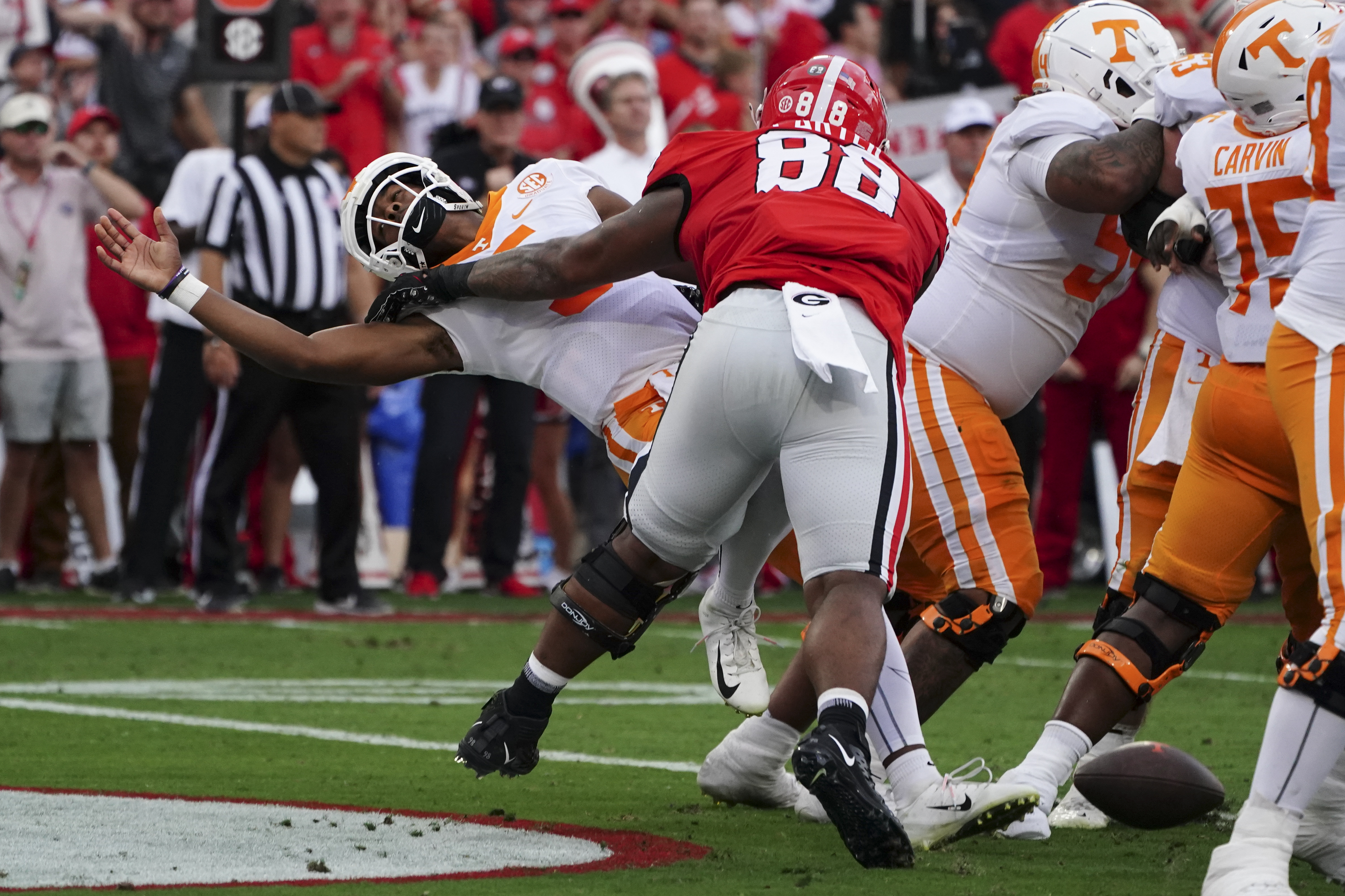 Tennessee quarterback Hendon Hooker, left, fumbles as he is hit by Georgia defensive lineman Jalen Carter (88) in the end zone during the first half of an NCAA college football game Saturday, Nov. 5, 2022, in Athens, Ga. Tennessee recovered the ball and avoided a safety. 