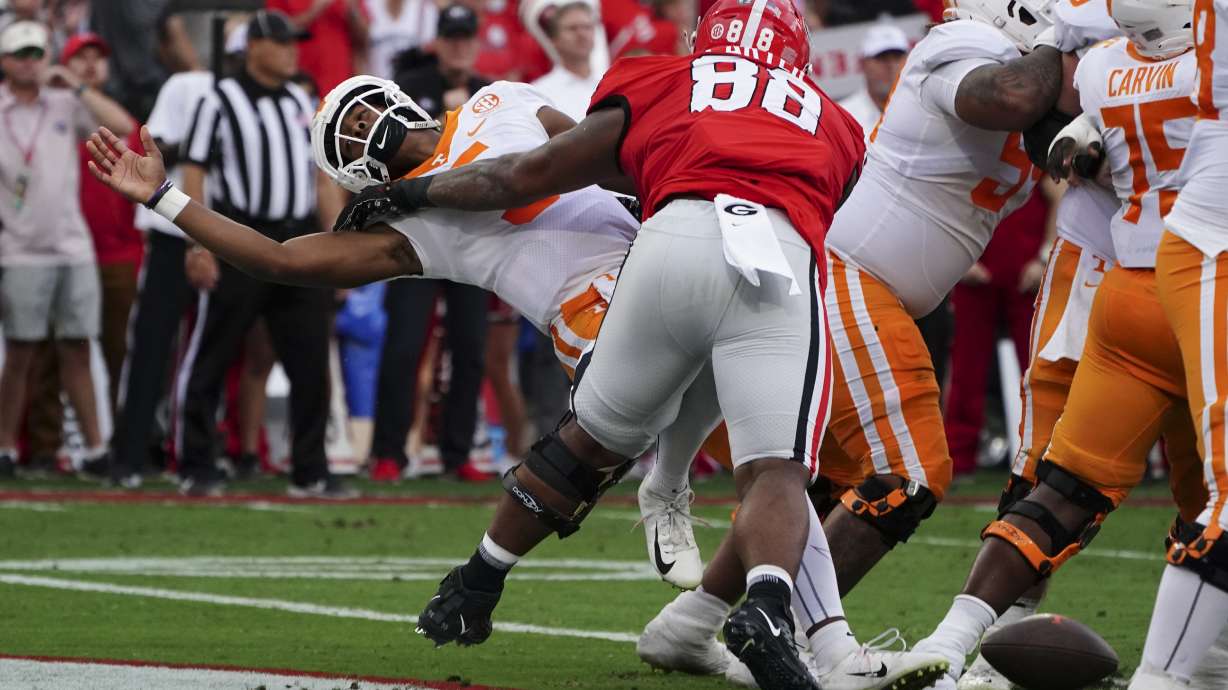 Tennessee quarterback Hendon Hooker, left, fumbles as he is hit by Georgia defensive lineman Jalen Carter (88) in the end zone during the first half of an NCAA college football game Saturday, Nov. 5, 2022, in Athens, Ga. Tennessee recovered the ball and avoided a safety.